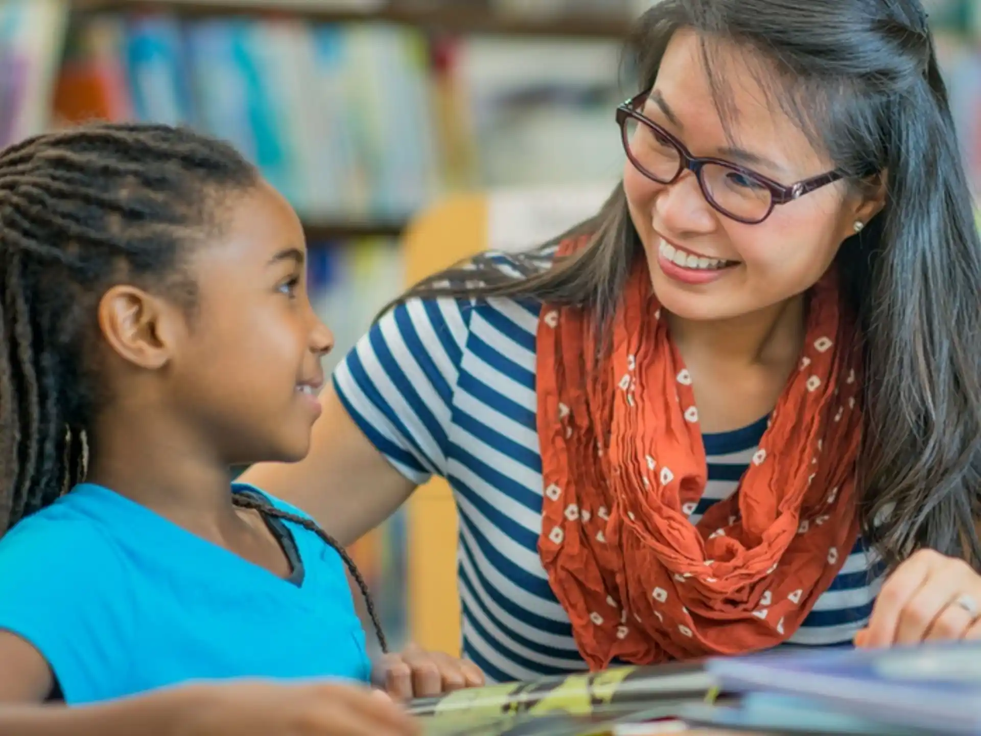 a woman and a child looking at a book