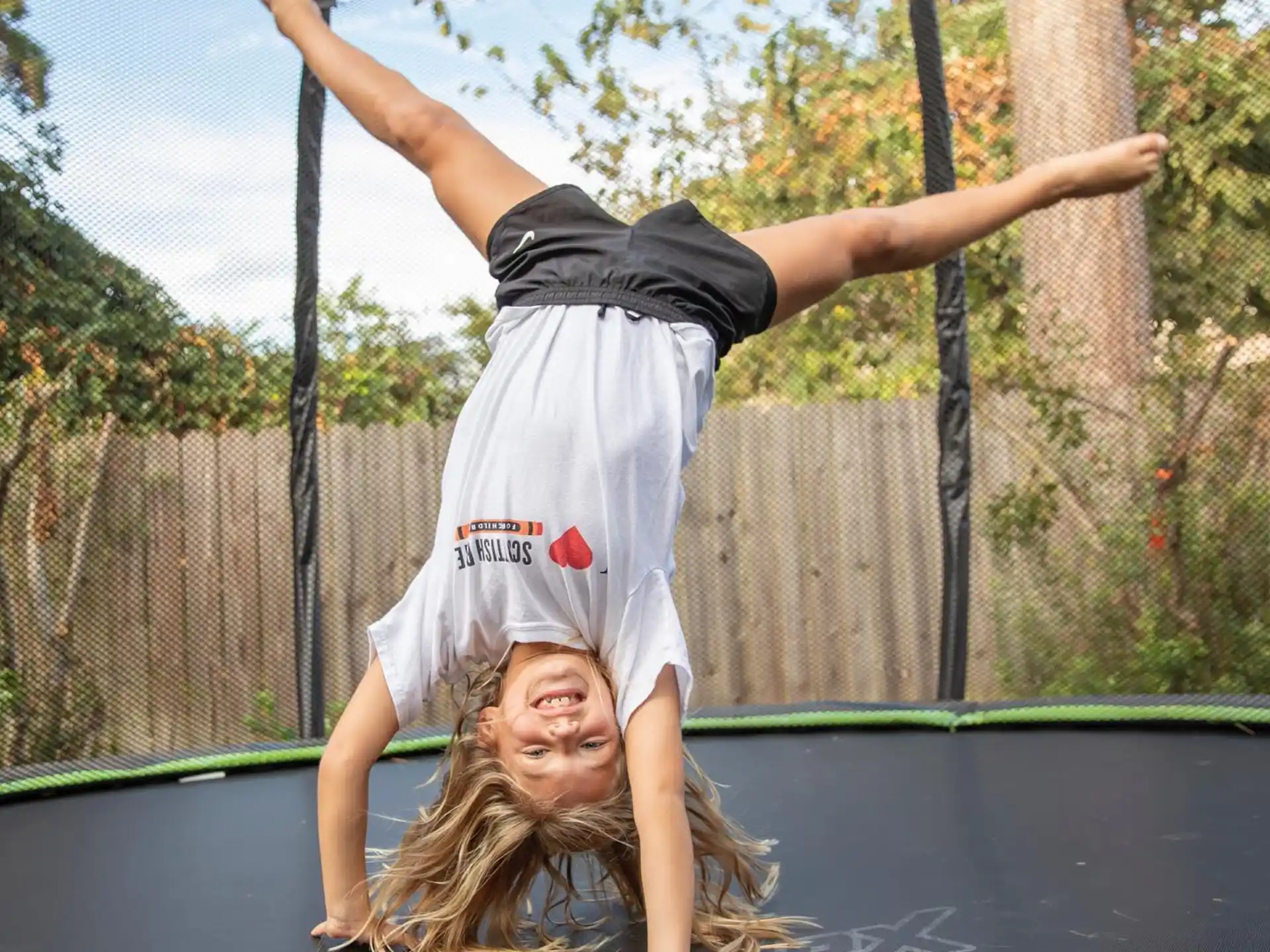 a person doing a handstand on a trampoline