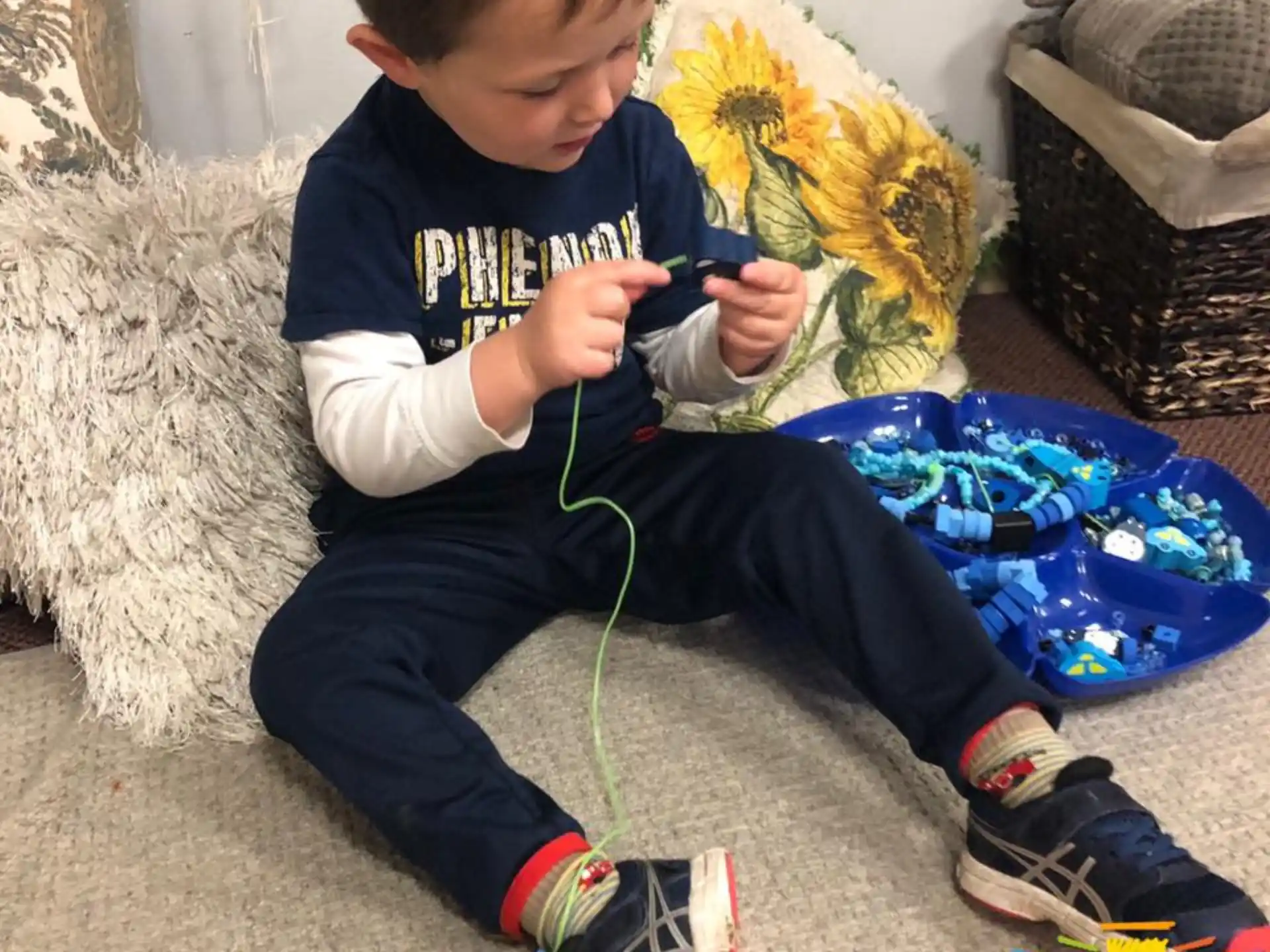 a boy sitting on the floor playing with a toy