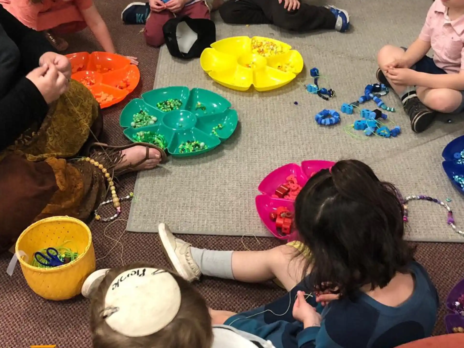 a group of people sitting on the ground with plates and cups