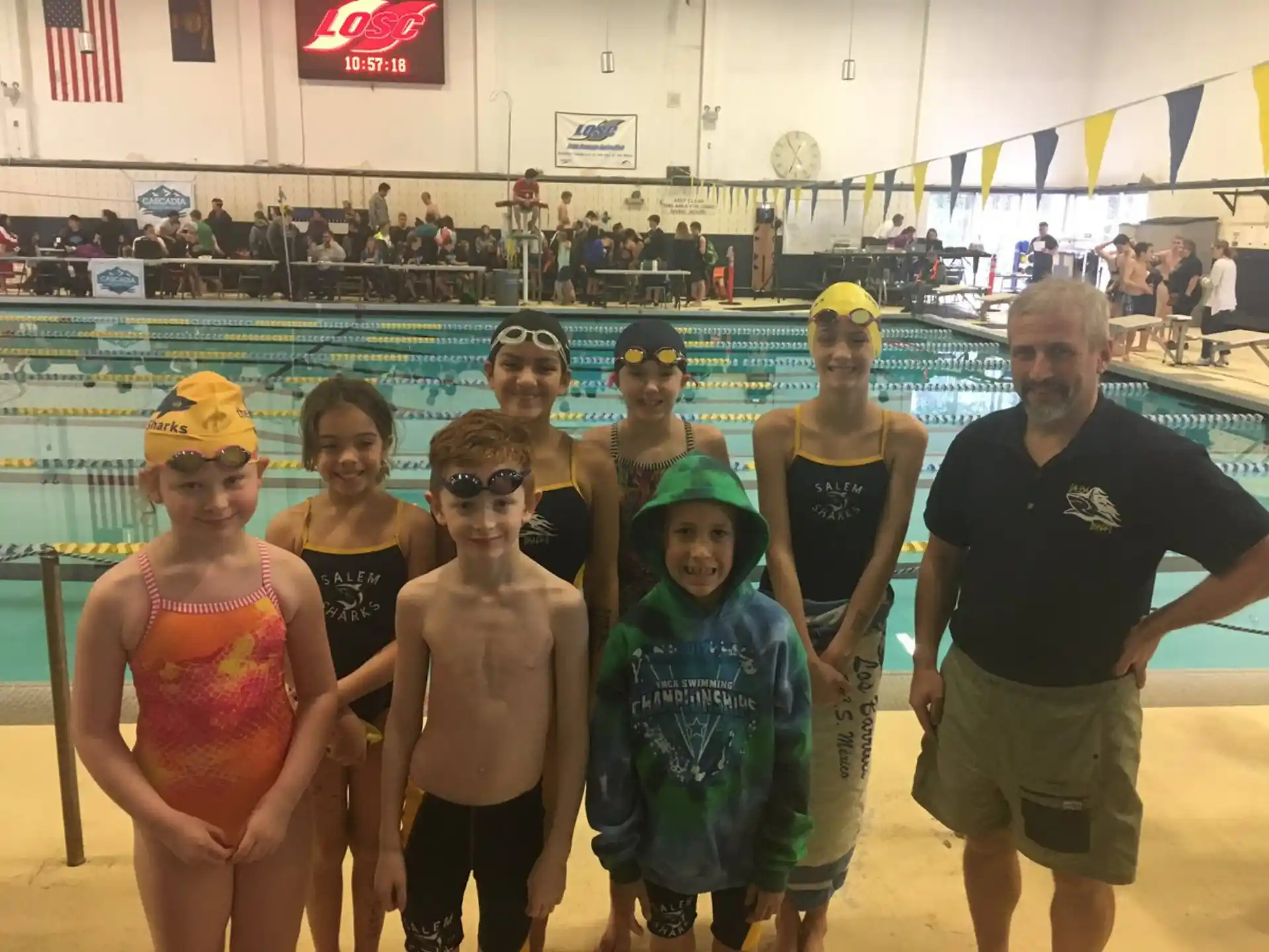 a group of people posing for a photo in front of a pool