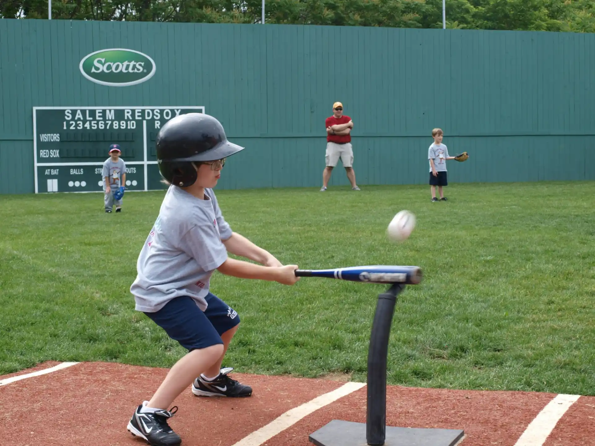 a kid hitting a ball with a baseball bat