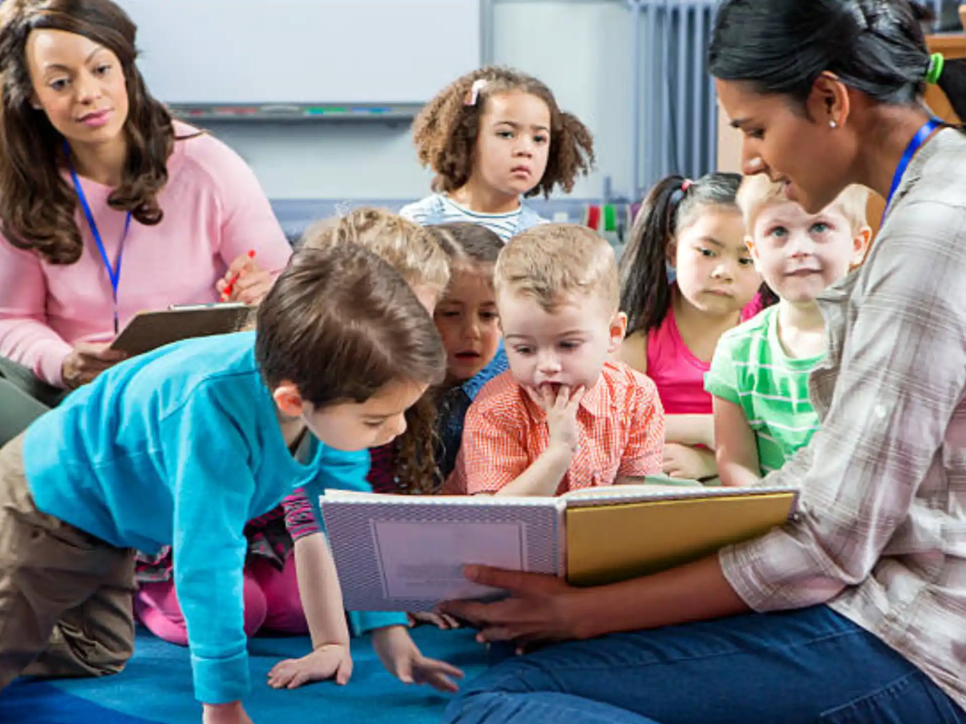 a group of children sitting on the floor reading books