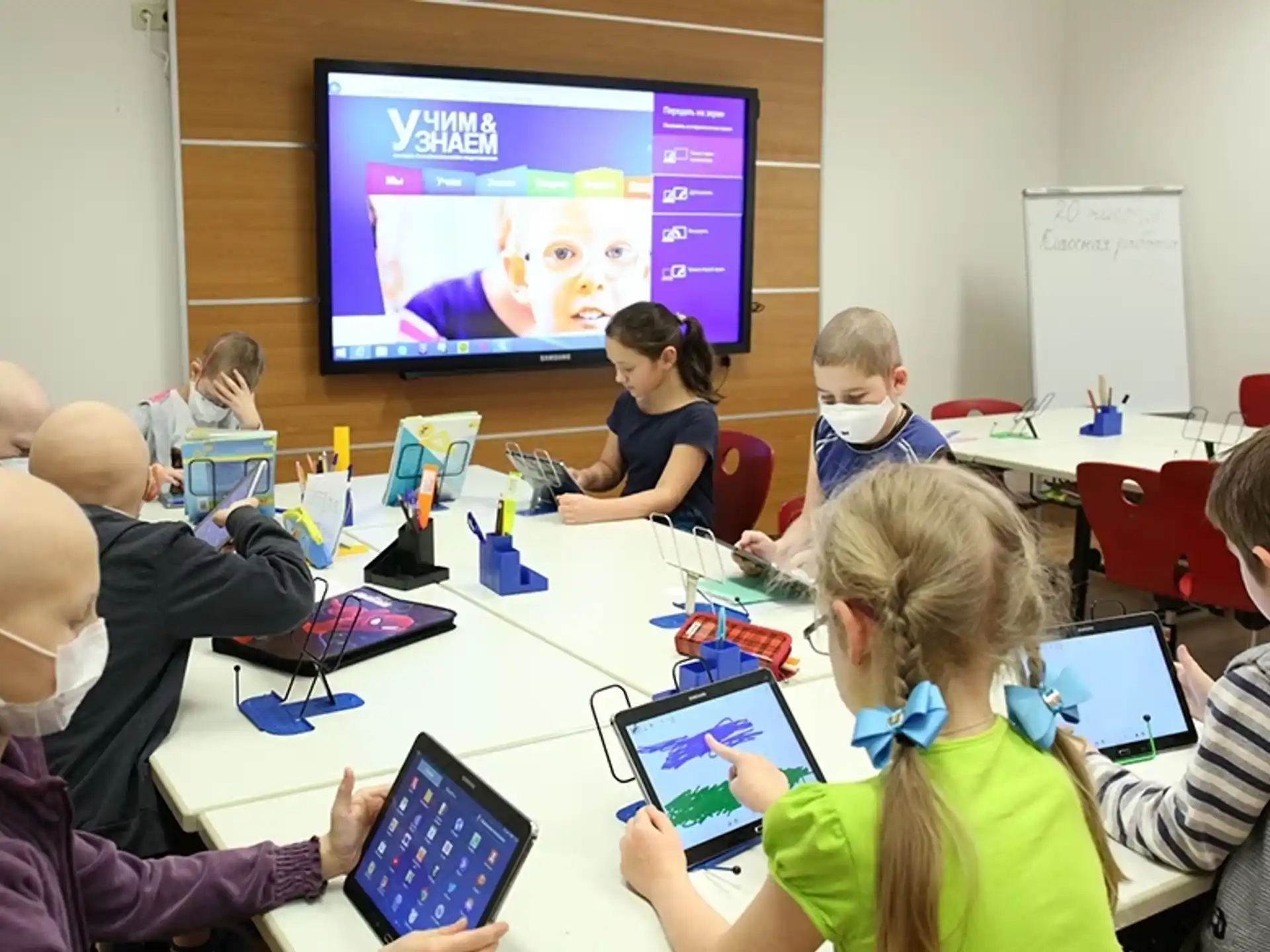 a group of people sitting around a table with laptops