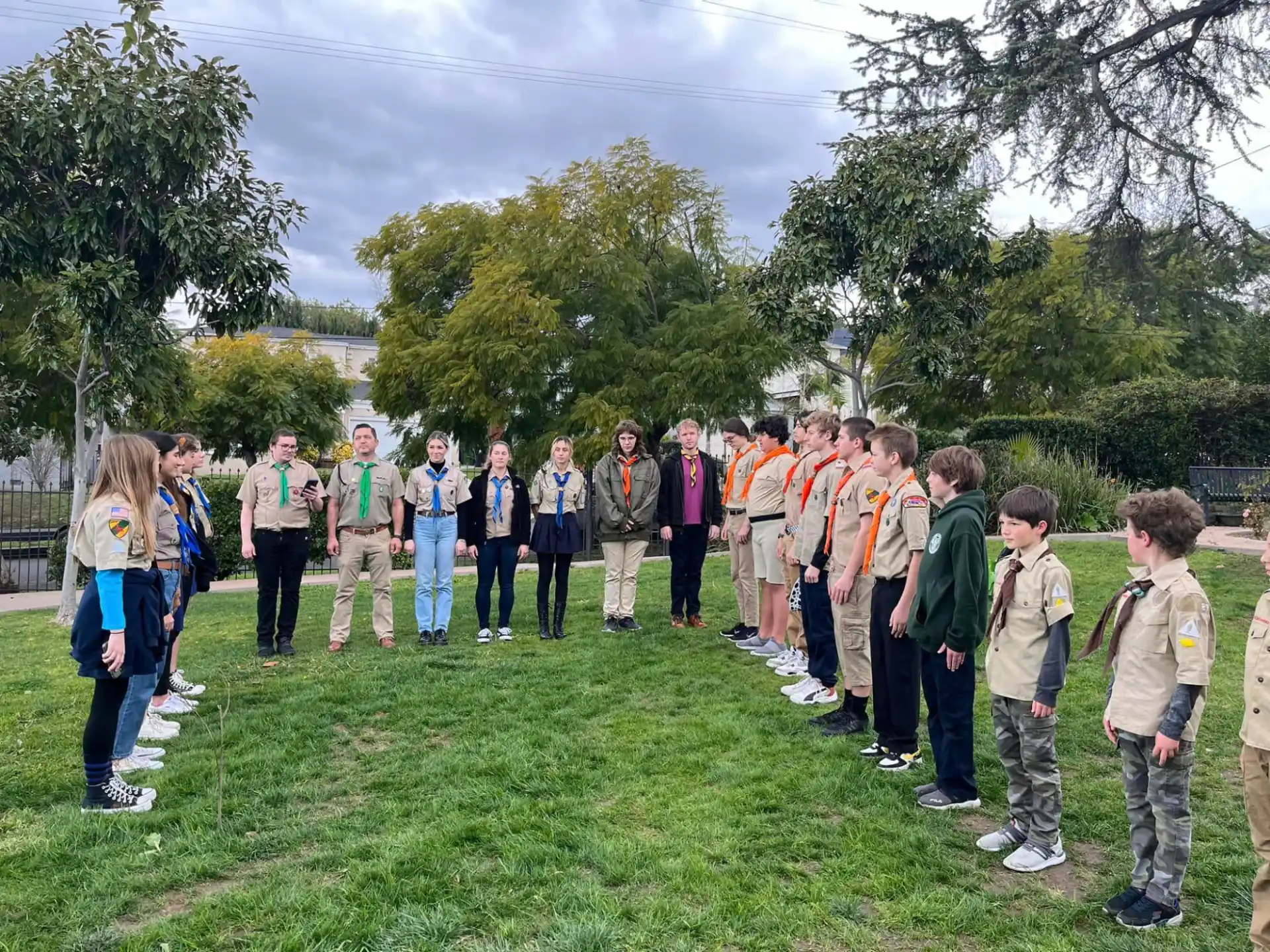 a group of people standing on a grass field
