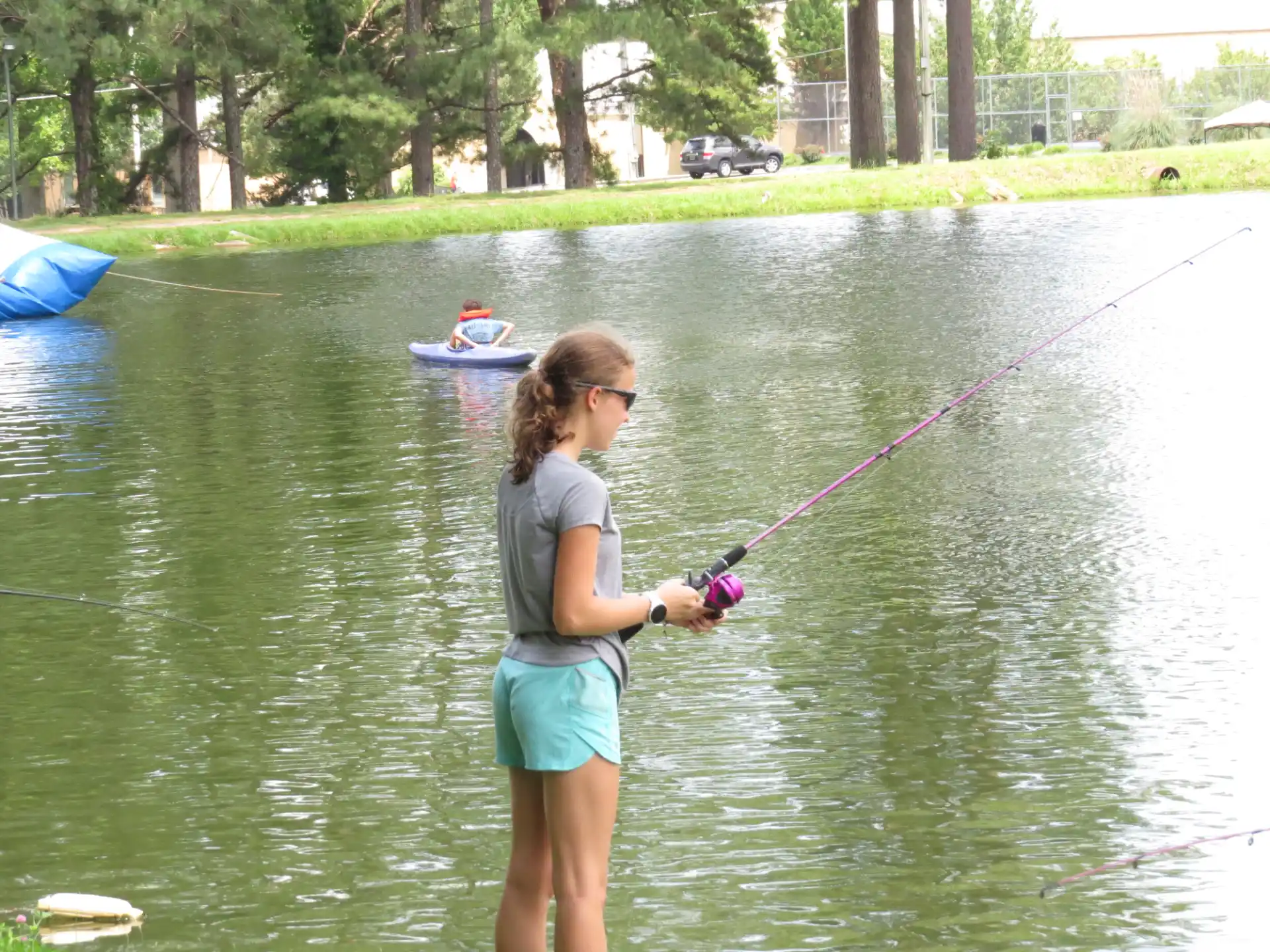 a woman holding a fishing pole in a lake