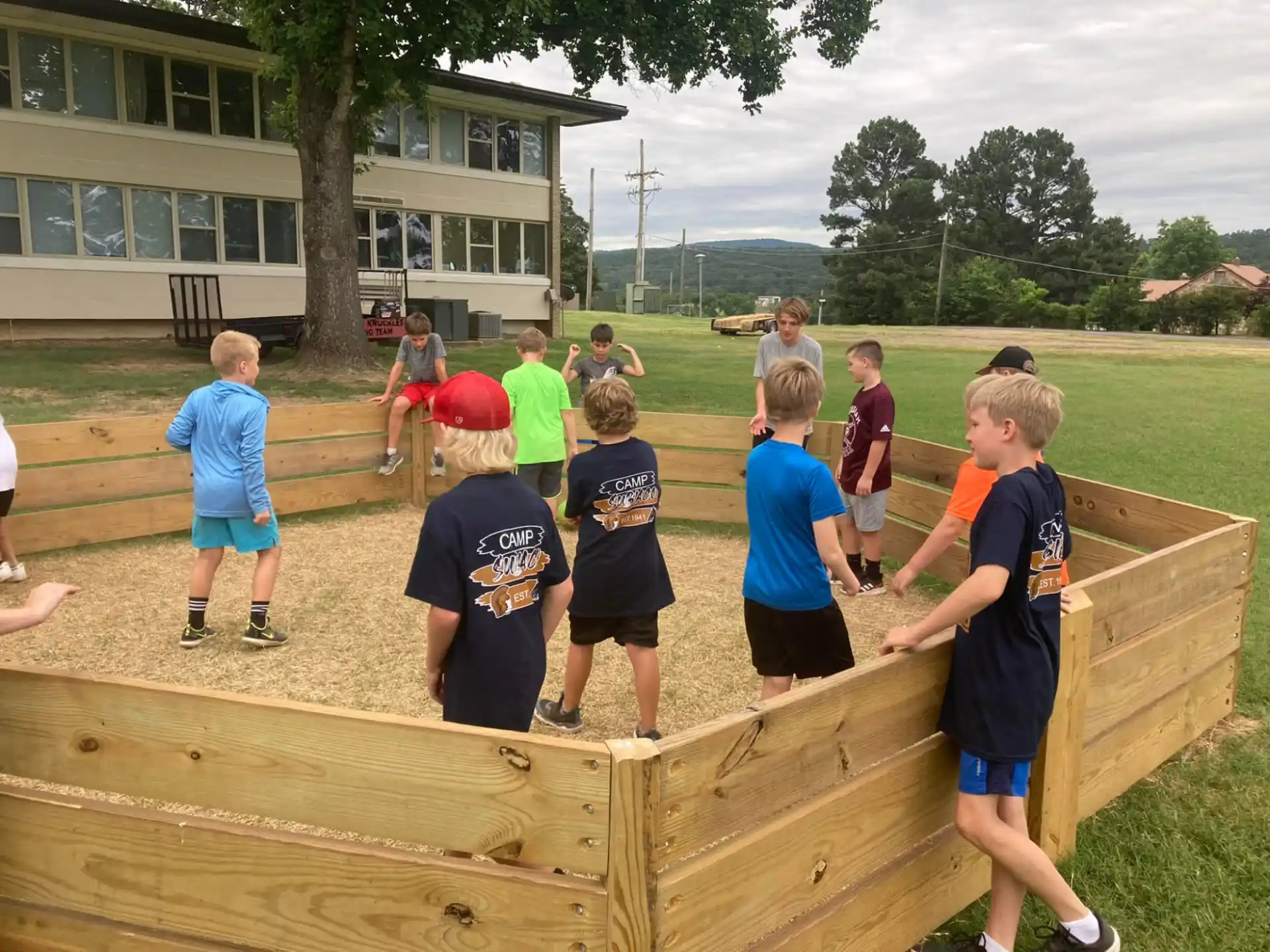 a group of kids standing on a wooden bench in front of a building