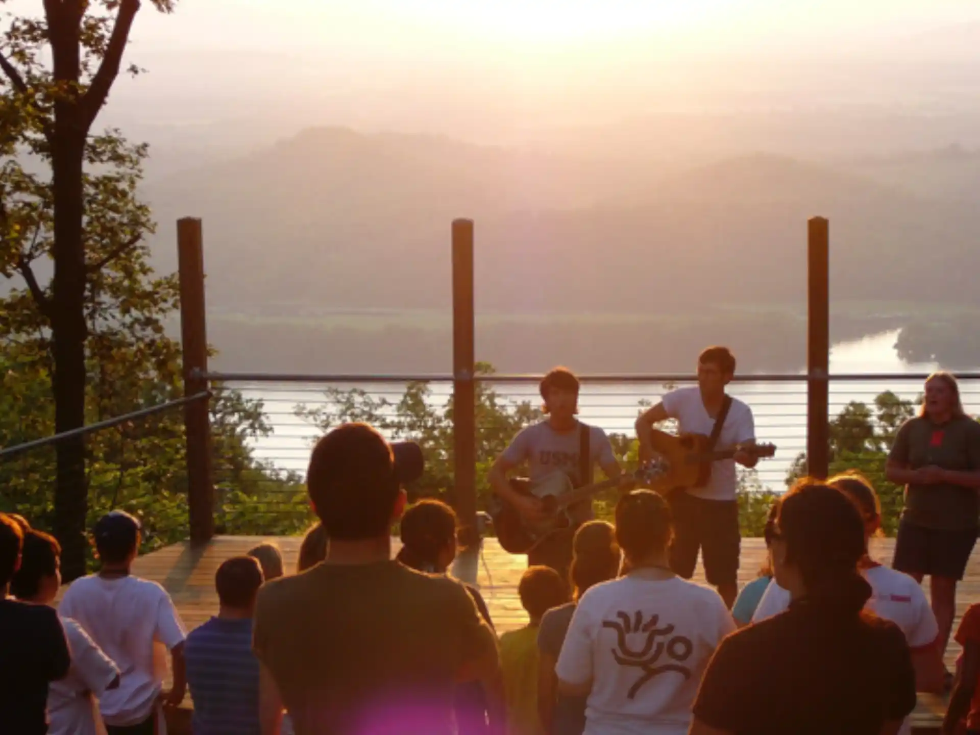 a group of people standing on a stage with a person playing a guitar