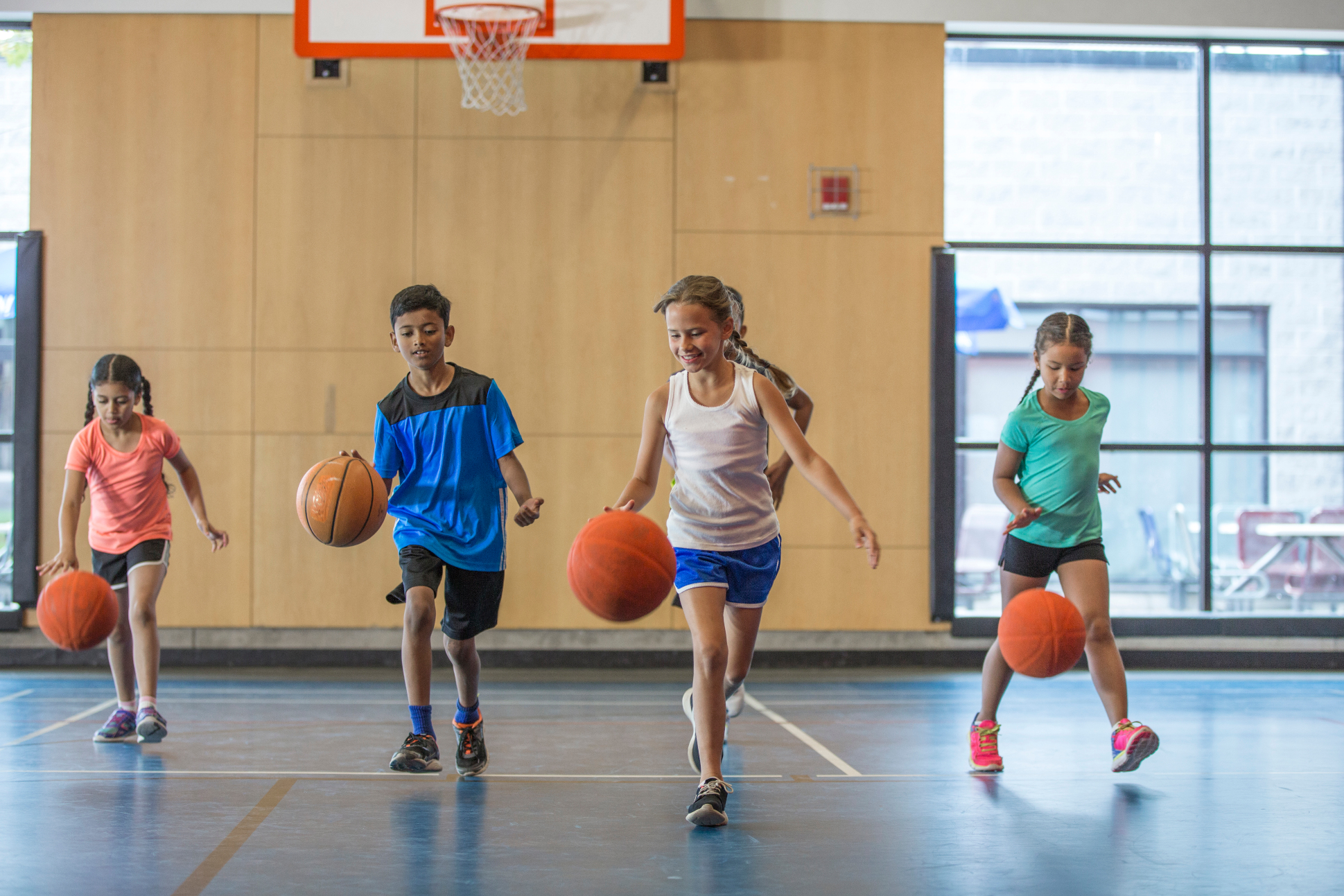 a group of kids playing basketball