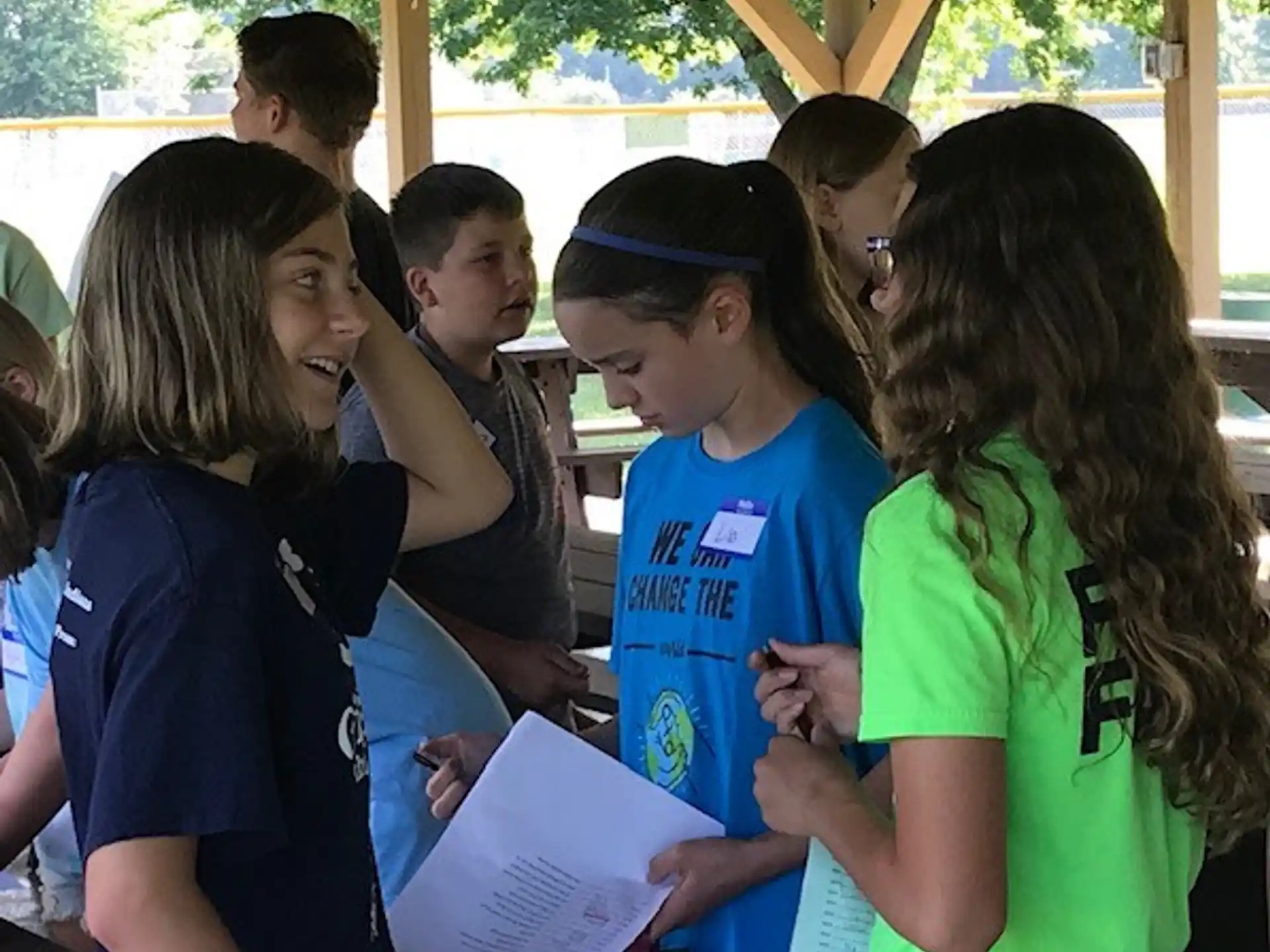 a group of children looking at a paper