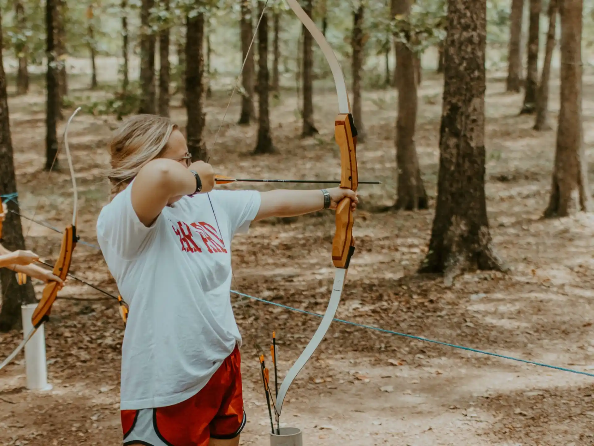 a man shooting bows in the woods
