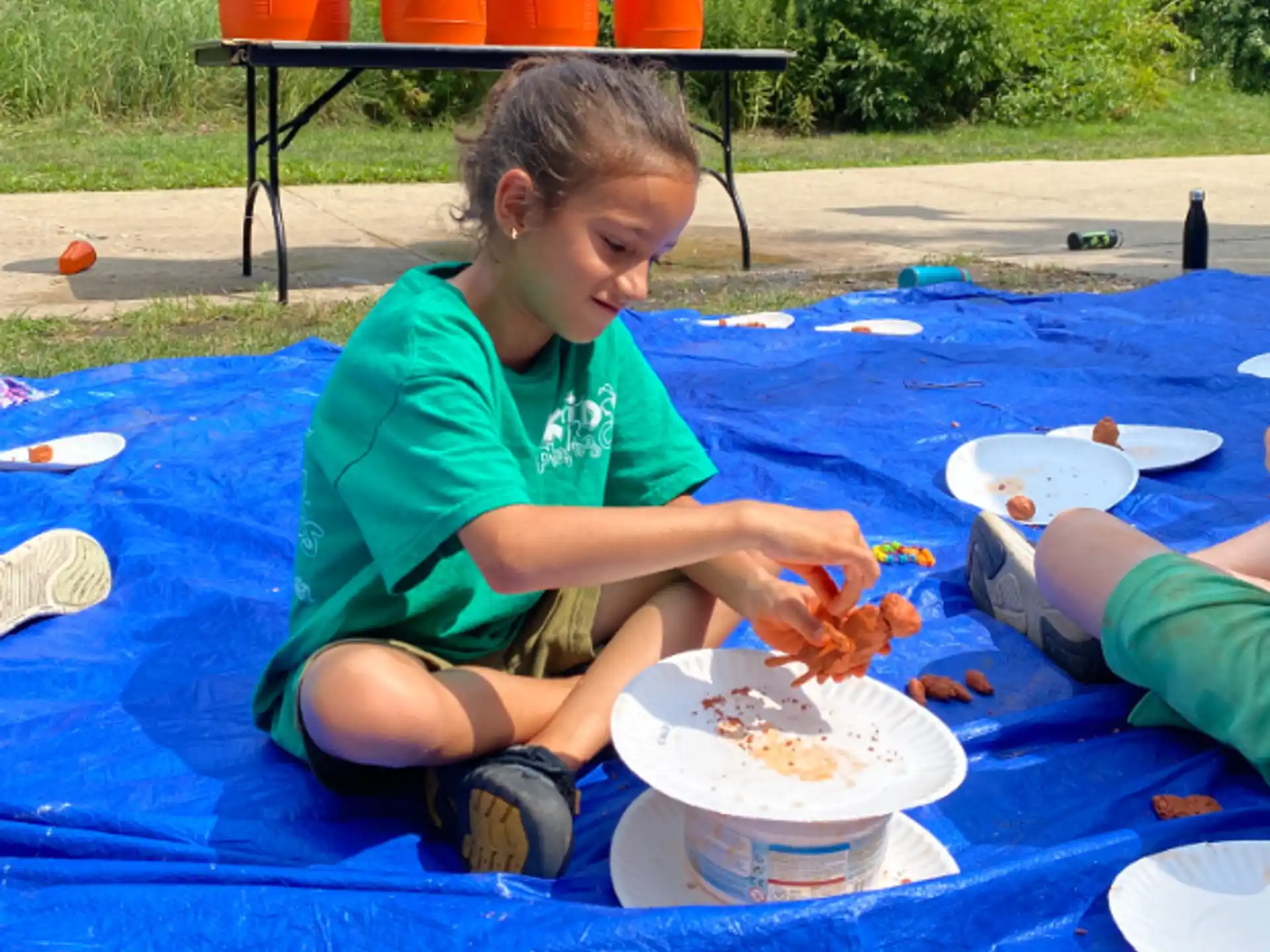 a child sitting on a blanket eating food