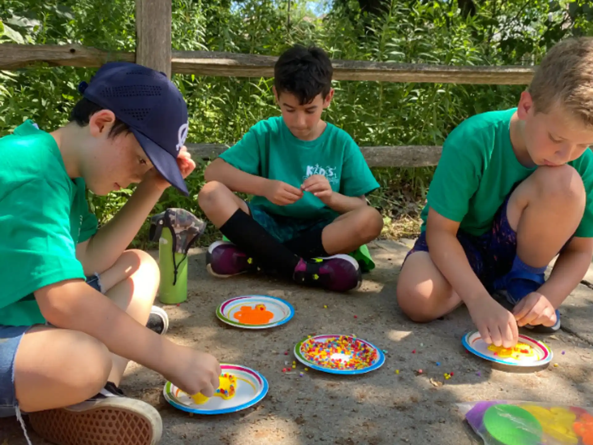a group of kids sitting on the ground eating