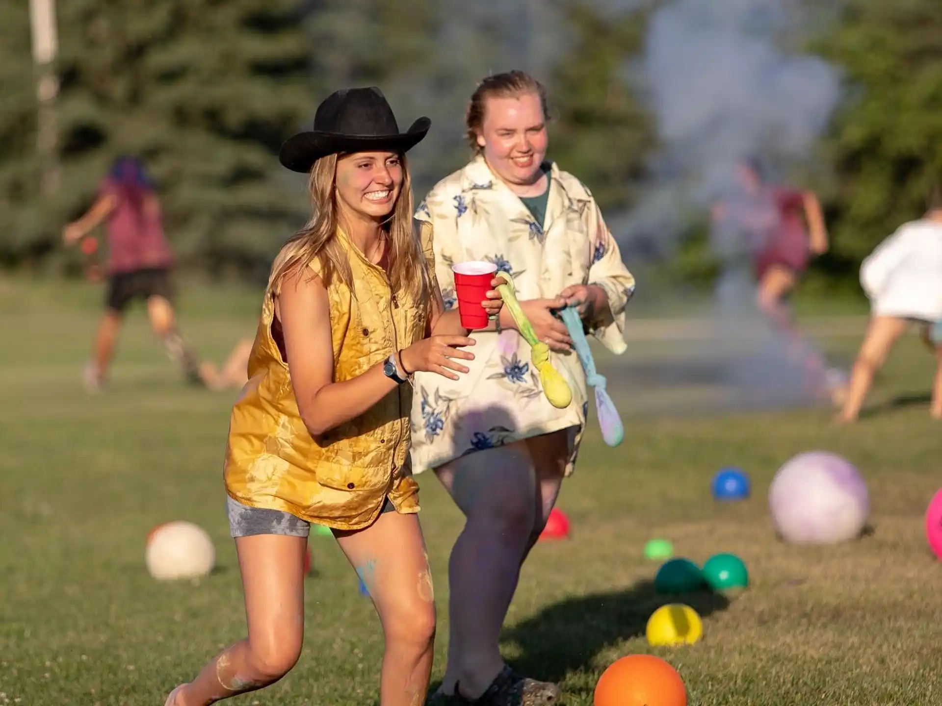 a man and woman posing for a picture with balls in the grass