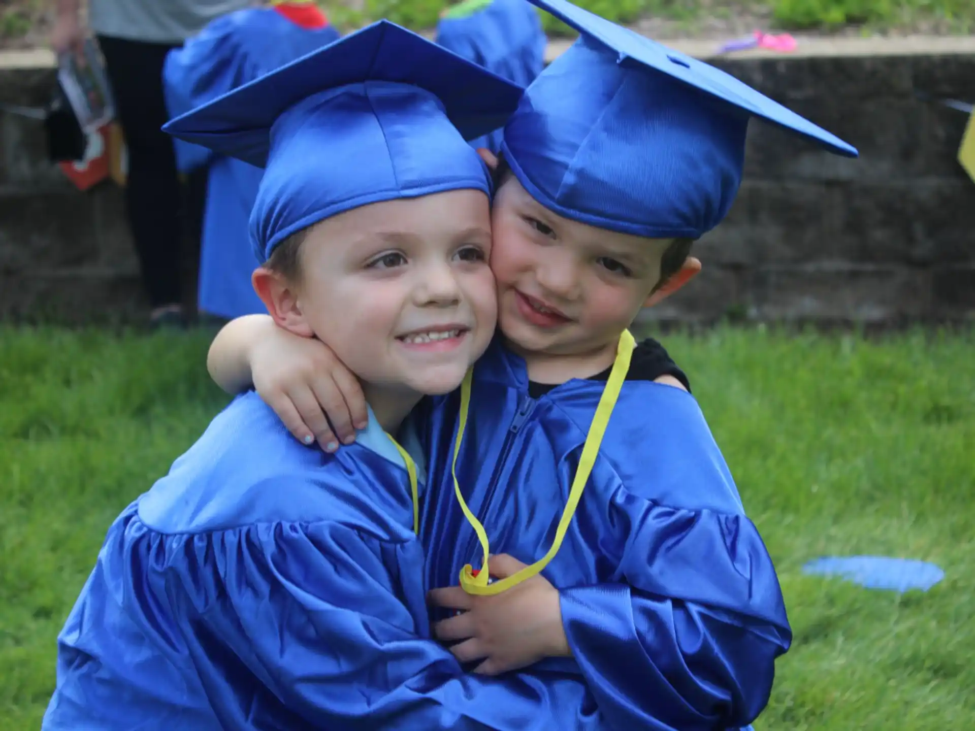 a couple of boys wearing graduation caps