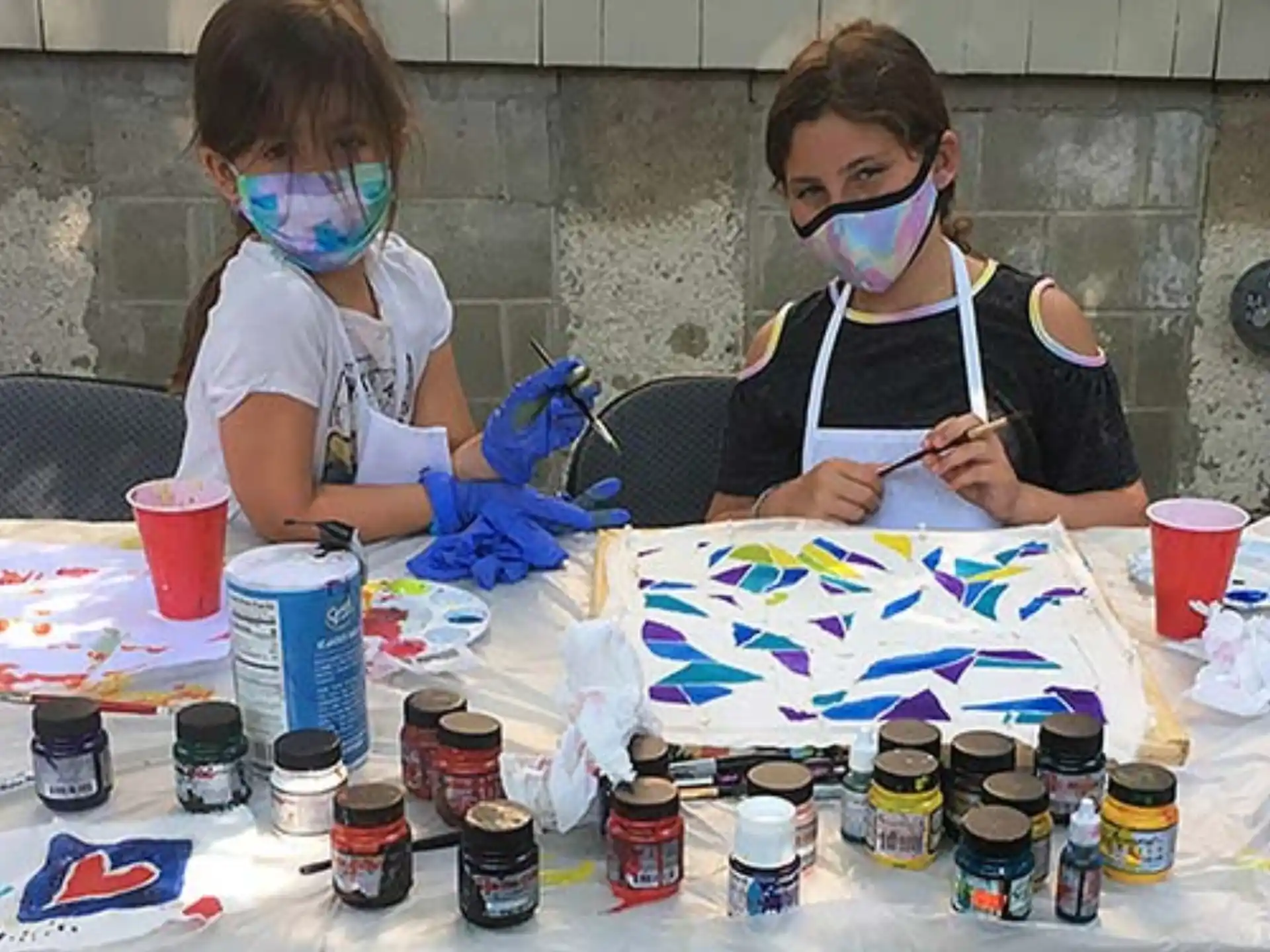 a couple of people wearing masks and paint on a table