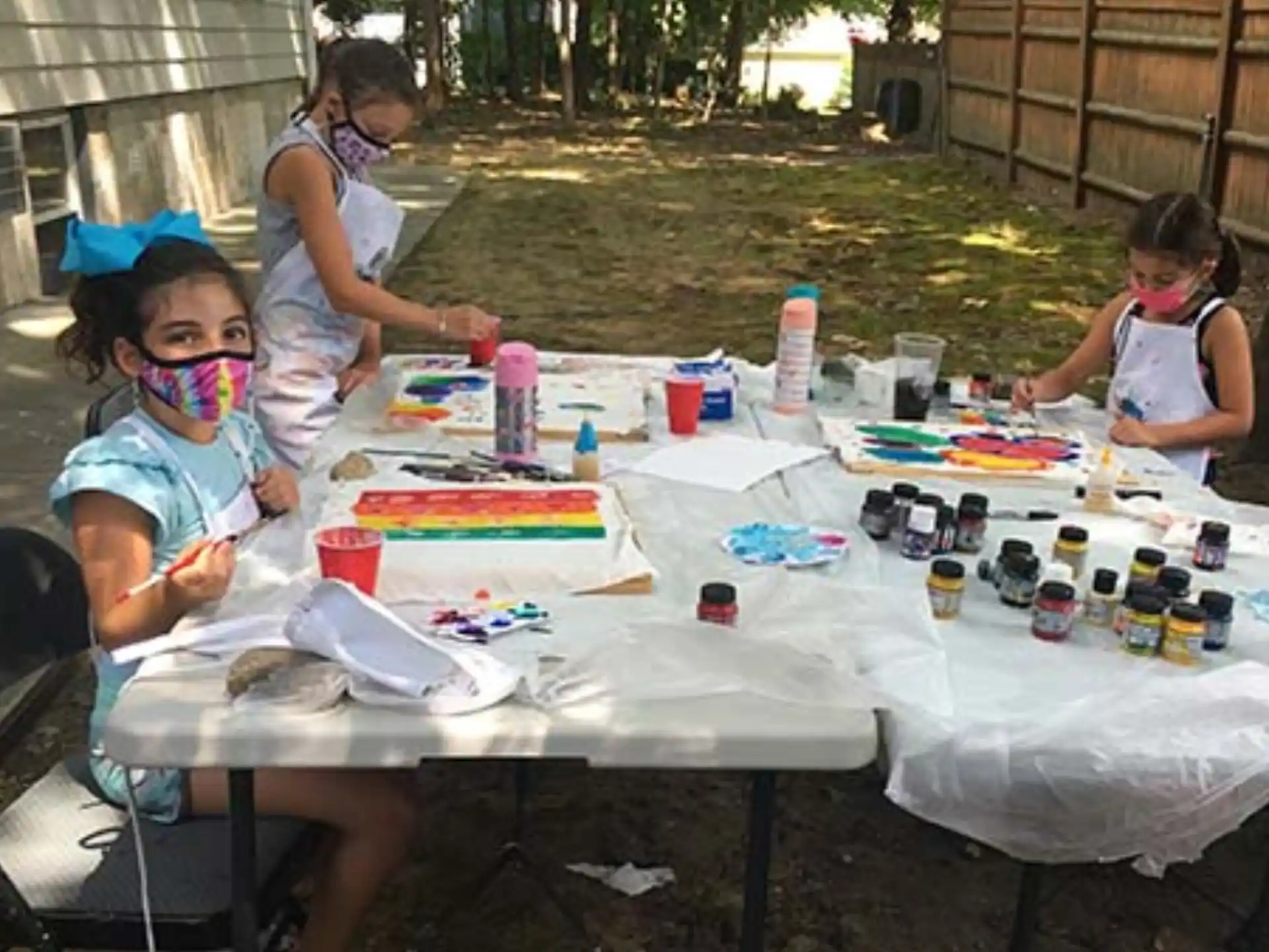 a group of children sitting around a table outside