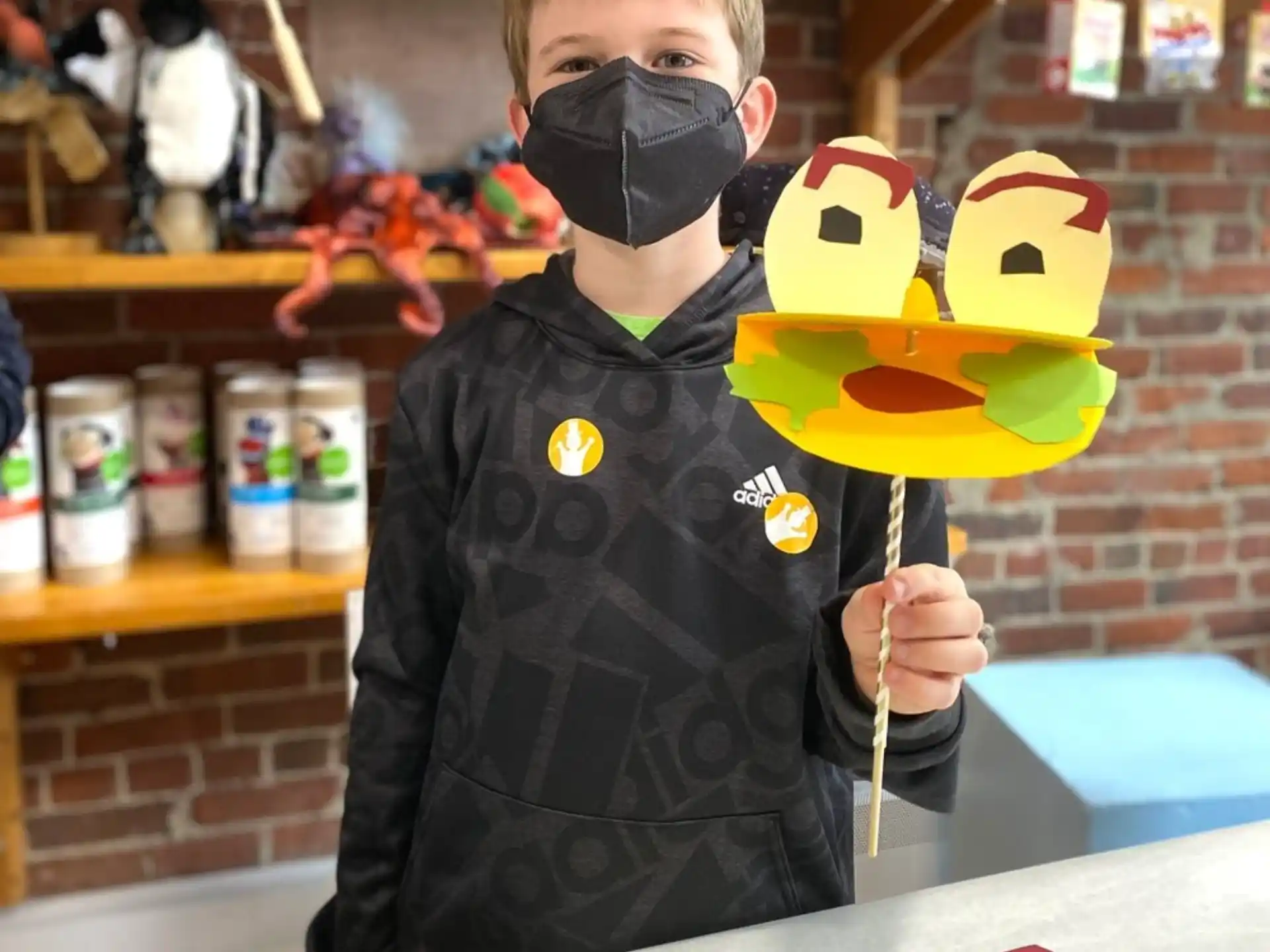 a boy holding a yellow and black toy