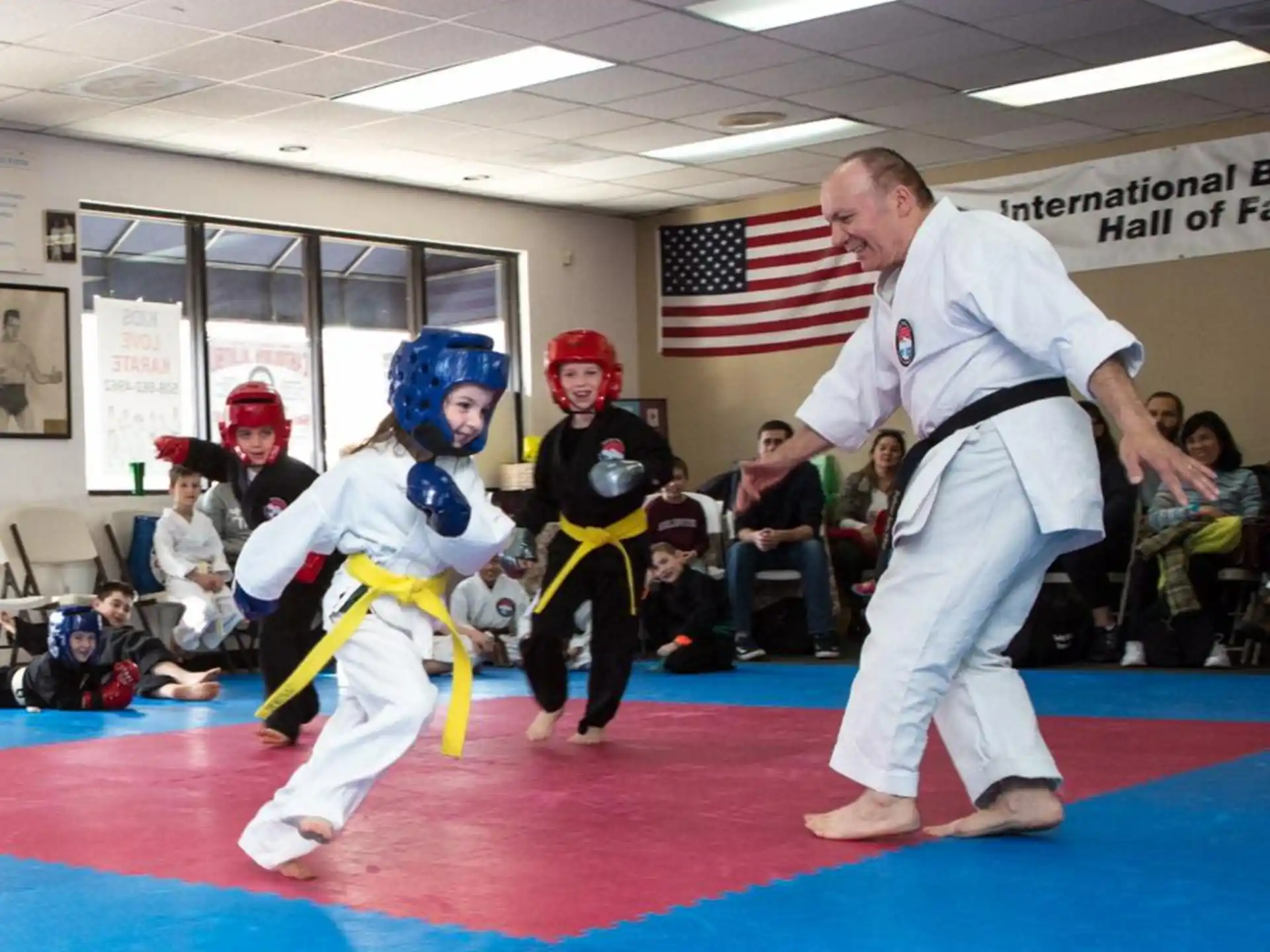 a person and two kids in karate uniforms