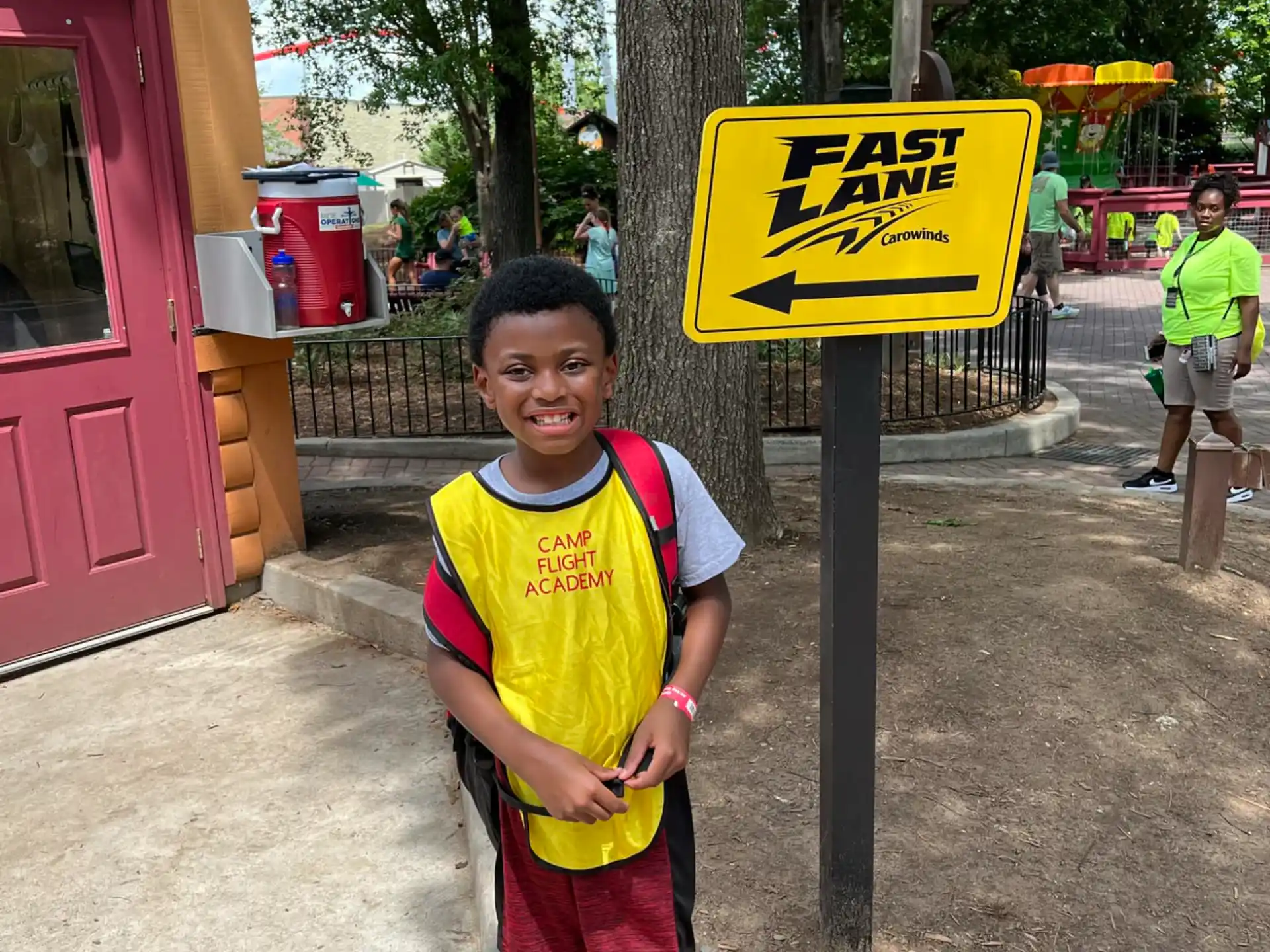 a boy standing next to a sign