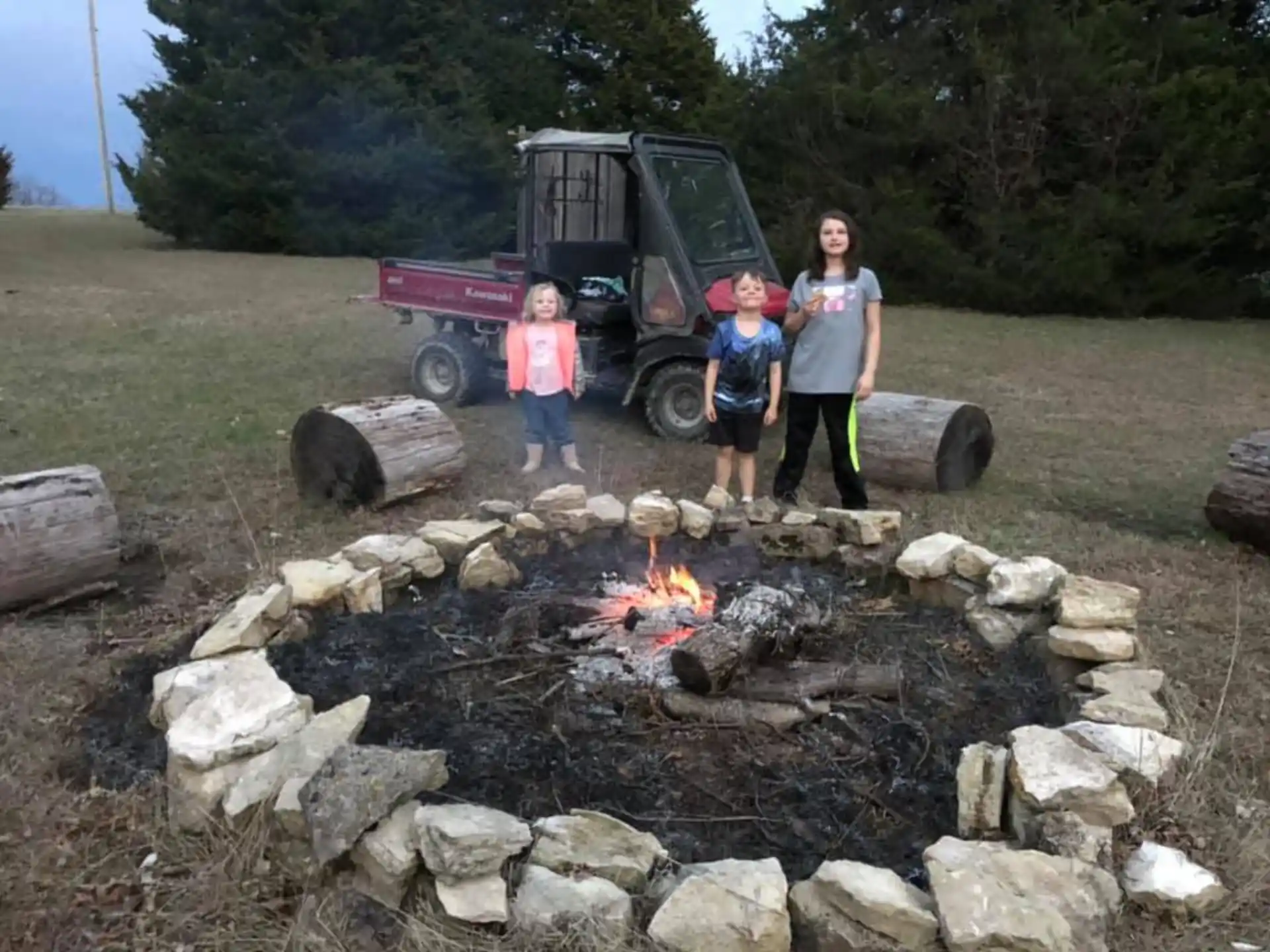 a group of people standing next to a truck and rocks