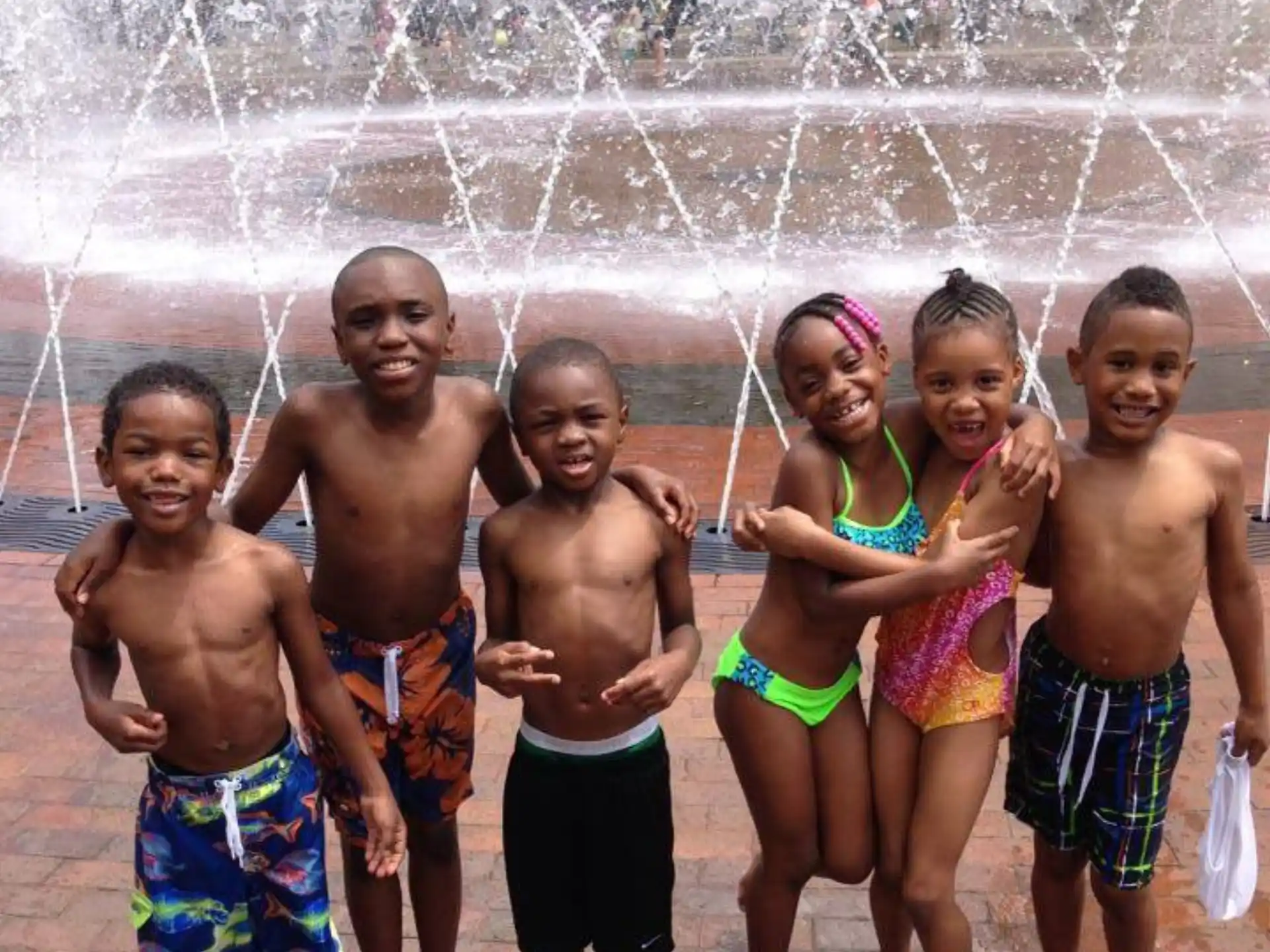 a group of people posing for a photo in front of a fountain