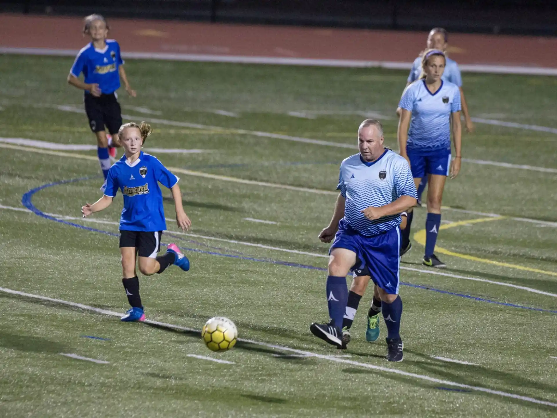 a group of girls compete over a football ball