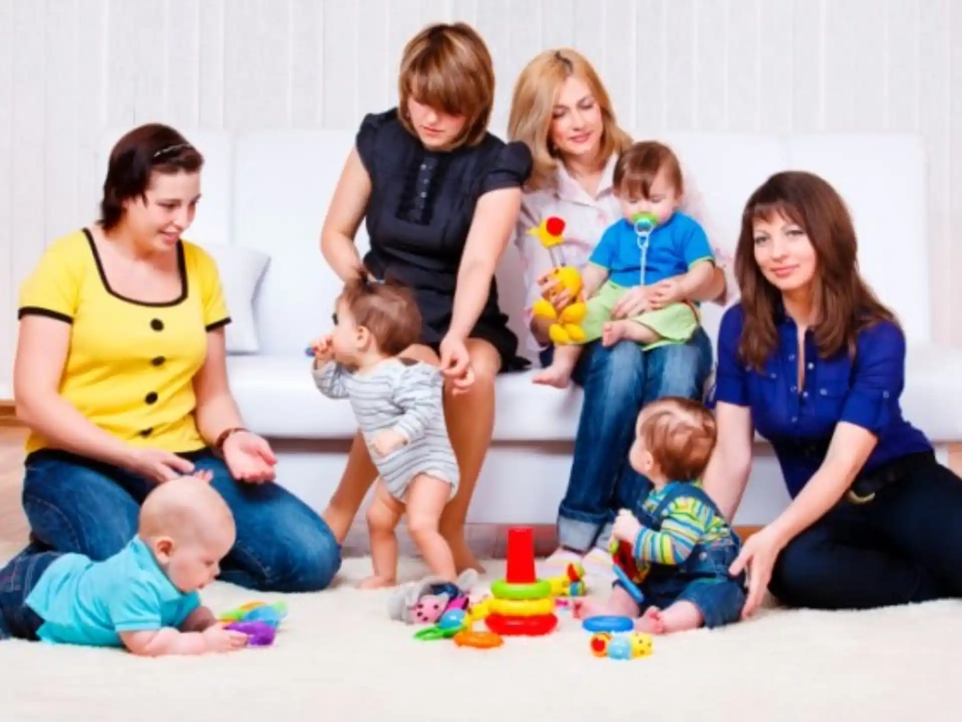 a group of people sitting on the floor with a baby