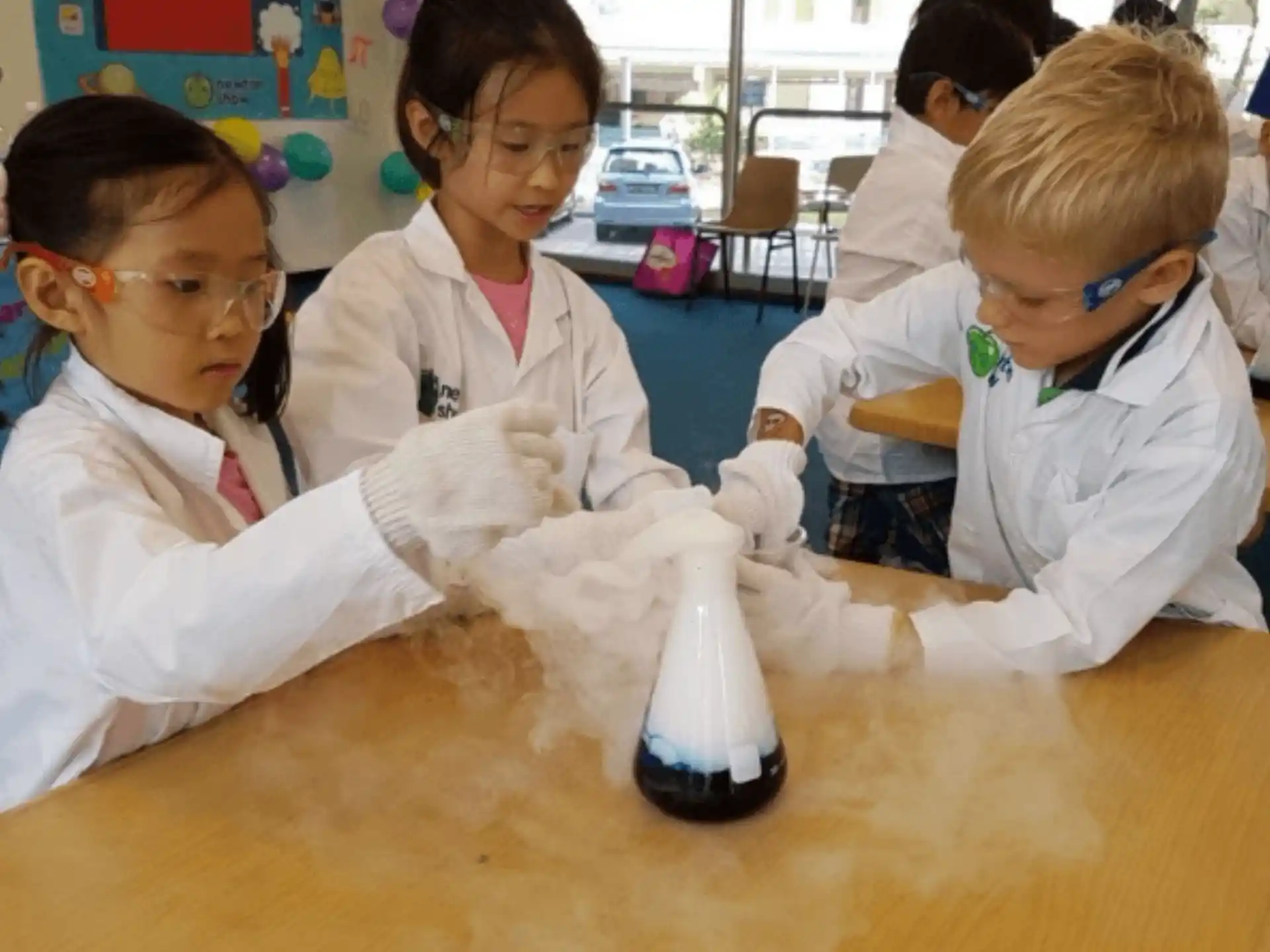 a group of children wearing white lab coats and gloves
