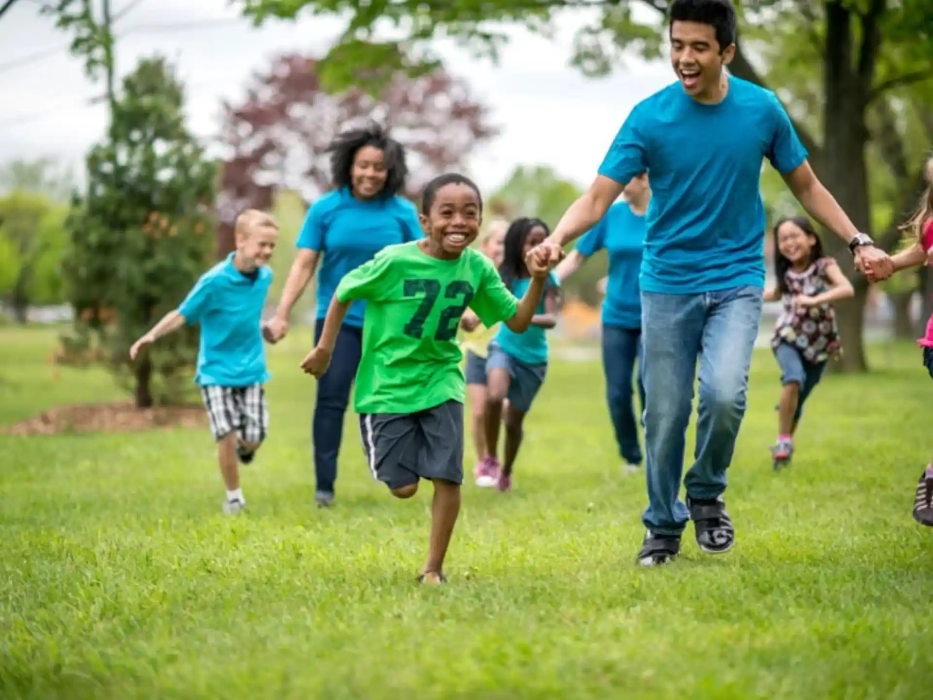 a group of people running on a grass field