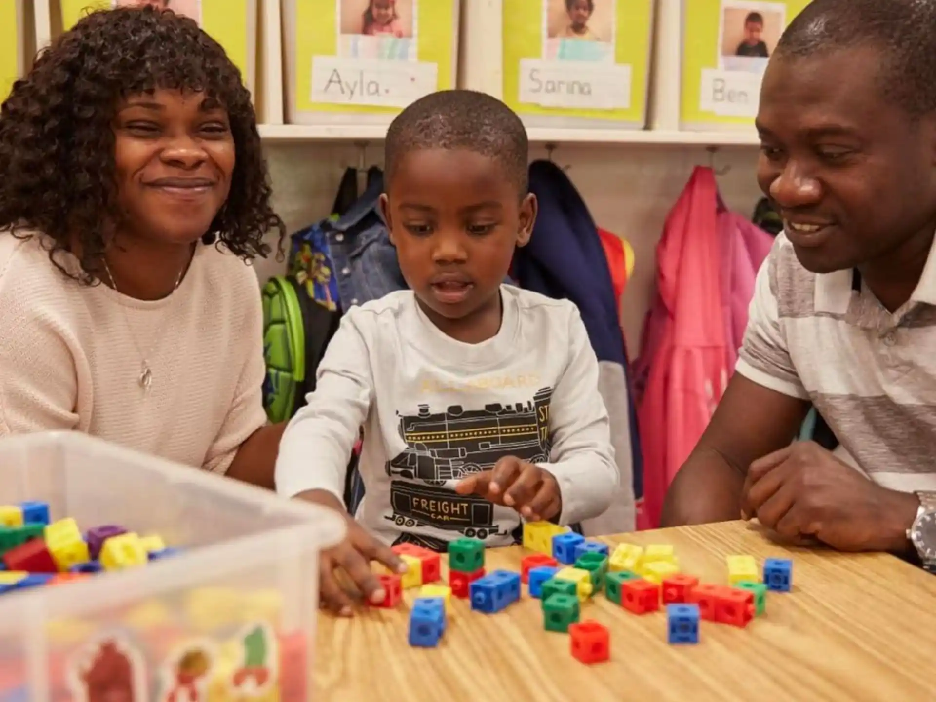 a group of people sitting at a table playing with toys