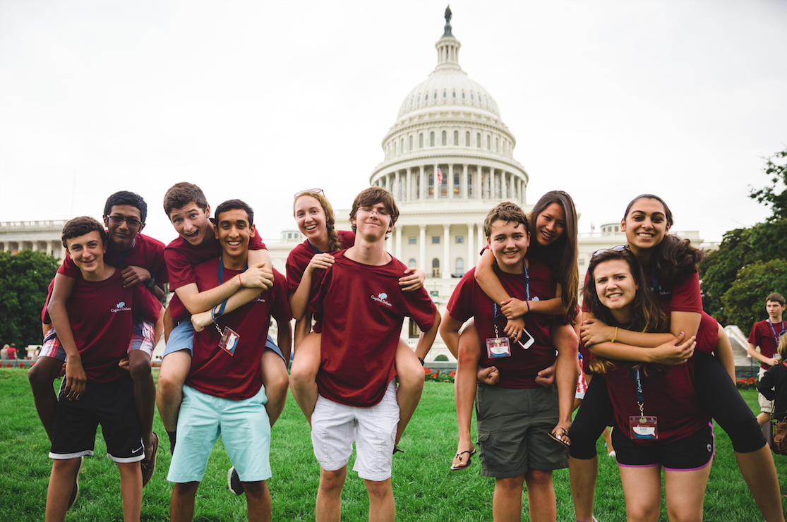 a group of people running in front of a white house