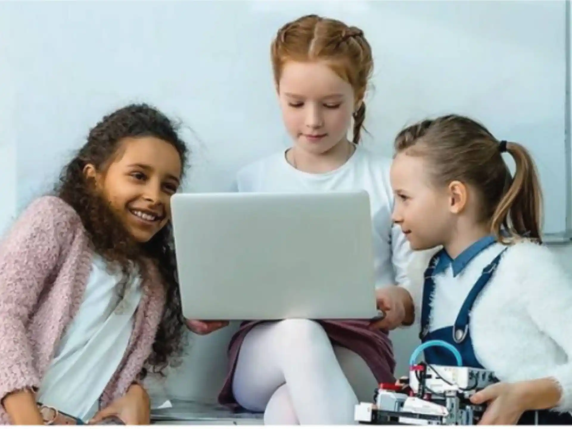 a group of children looking at a laptop
