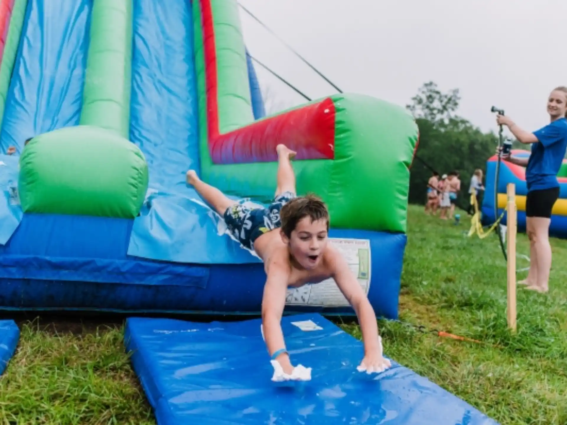 a person lying on a large green and blue slide