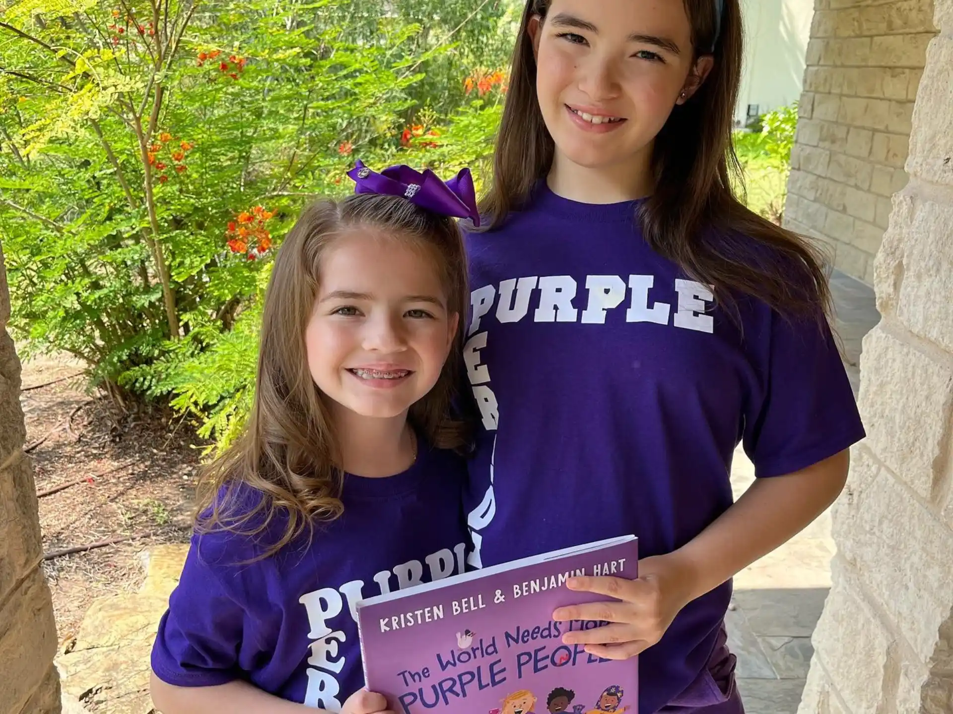 a couple of girls holding a sign