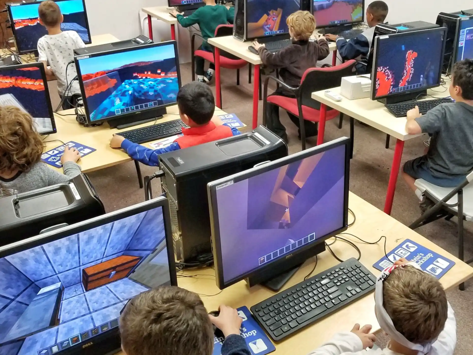 a group of people sitting at desks with computers