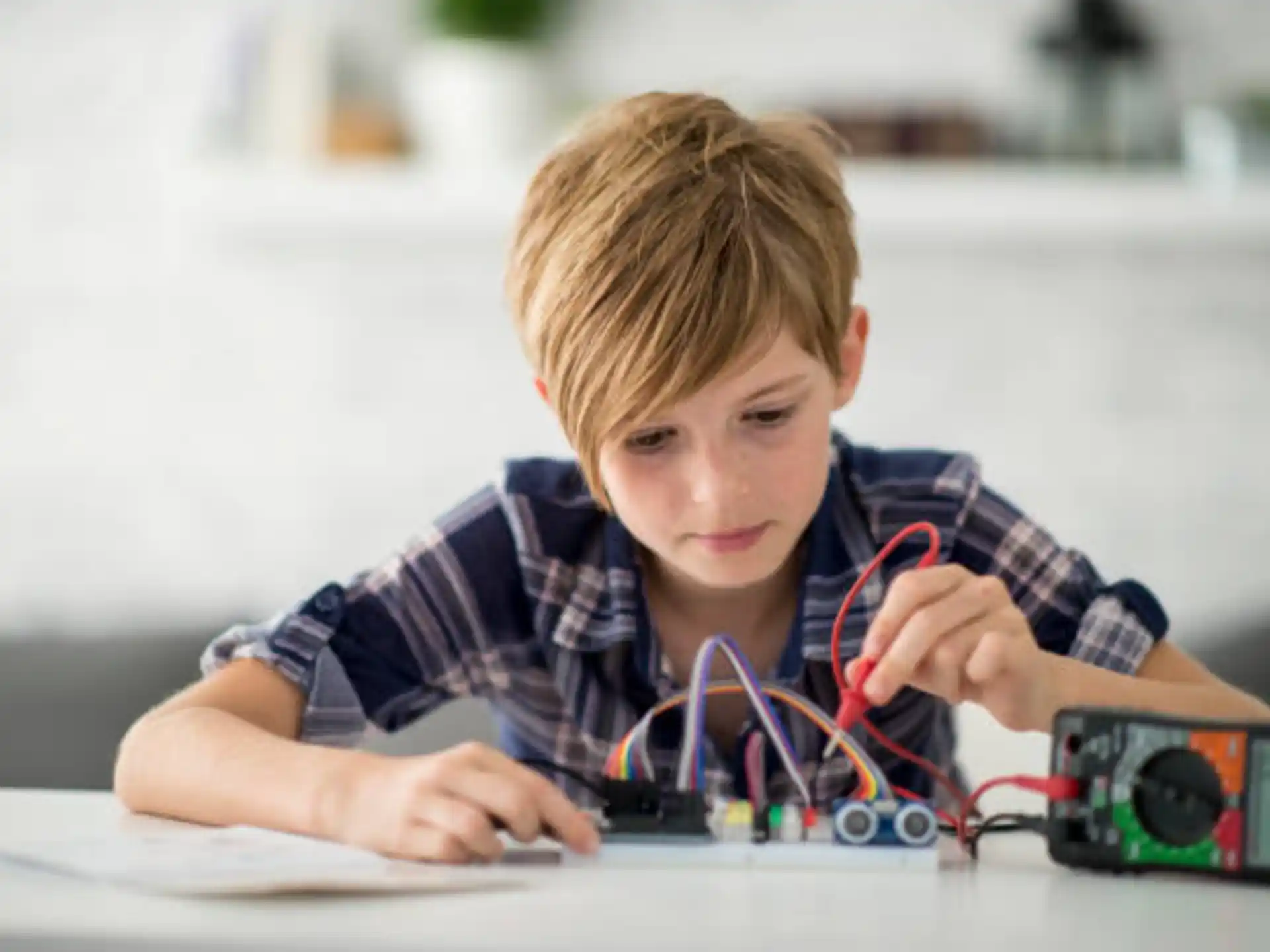 a young boy looking at a circuit board