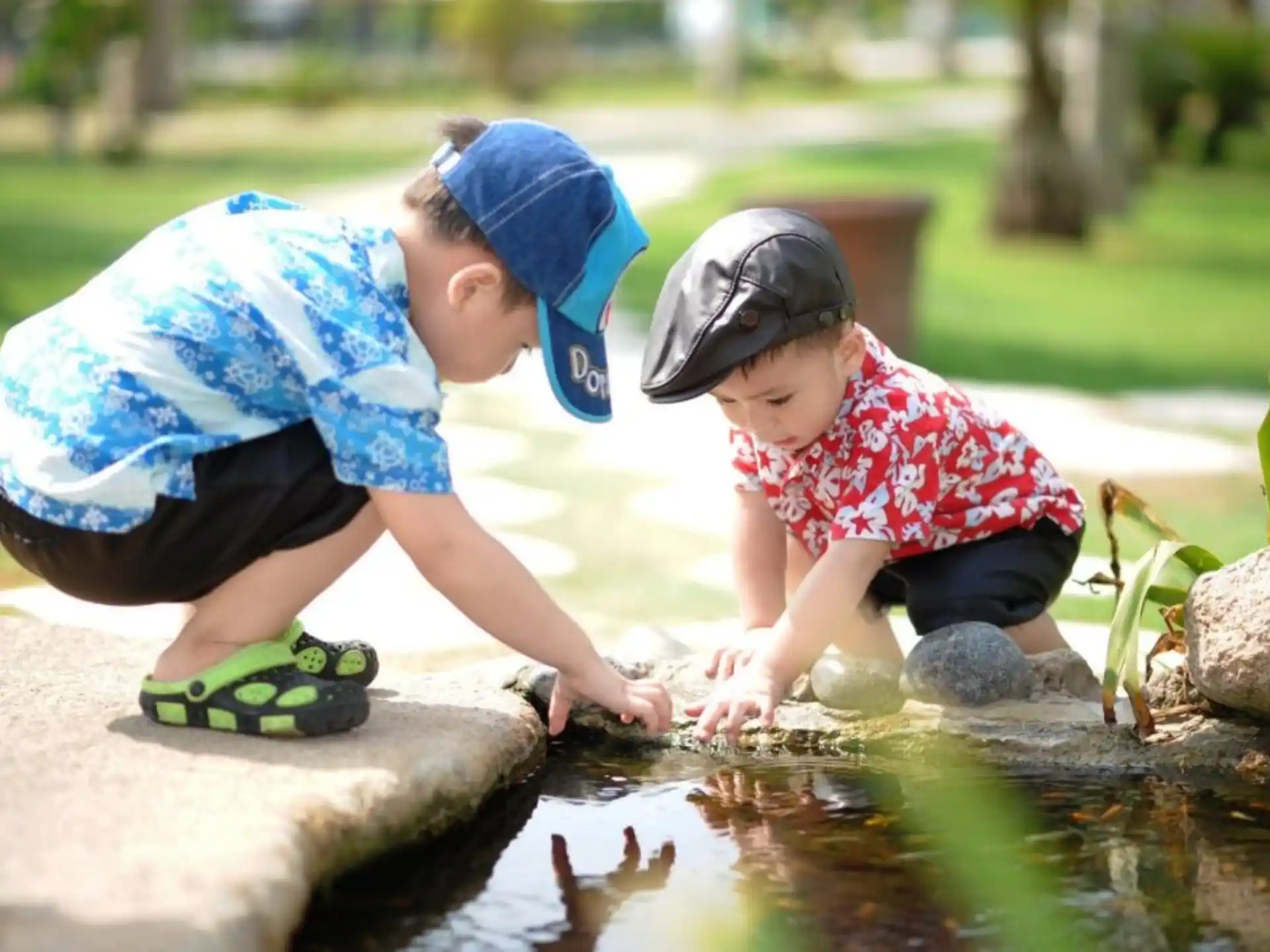 a couple of children playing in a pond