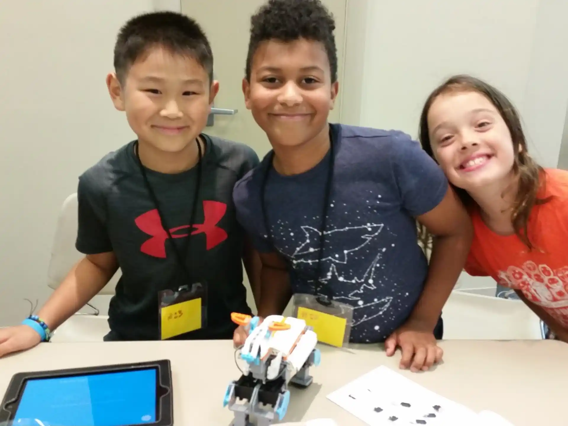 a group of kids sitting at a table with a toy
