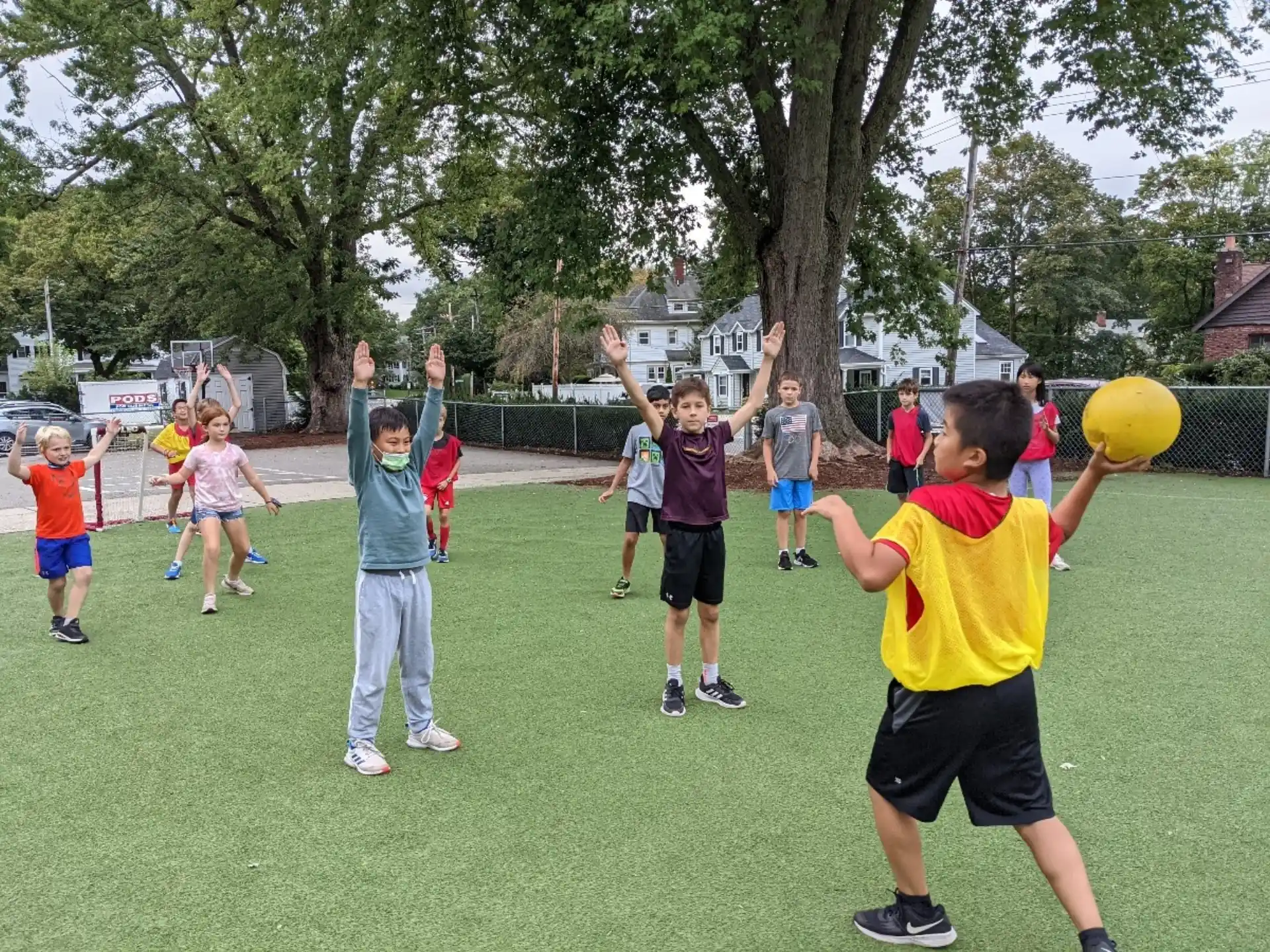a group of kids playing with a yellow ball