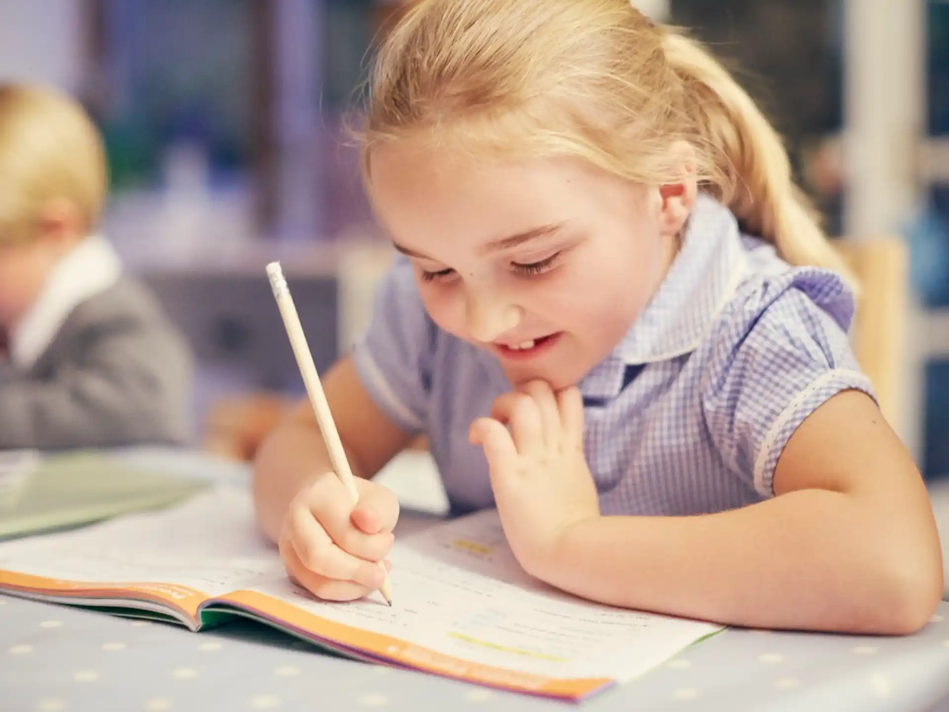 a young girl writing on a book