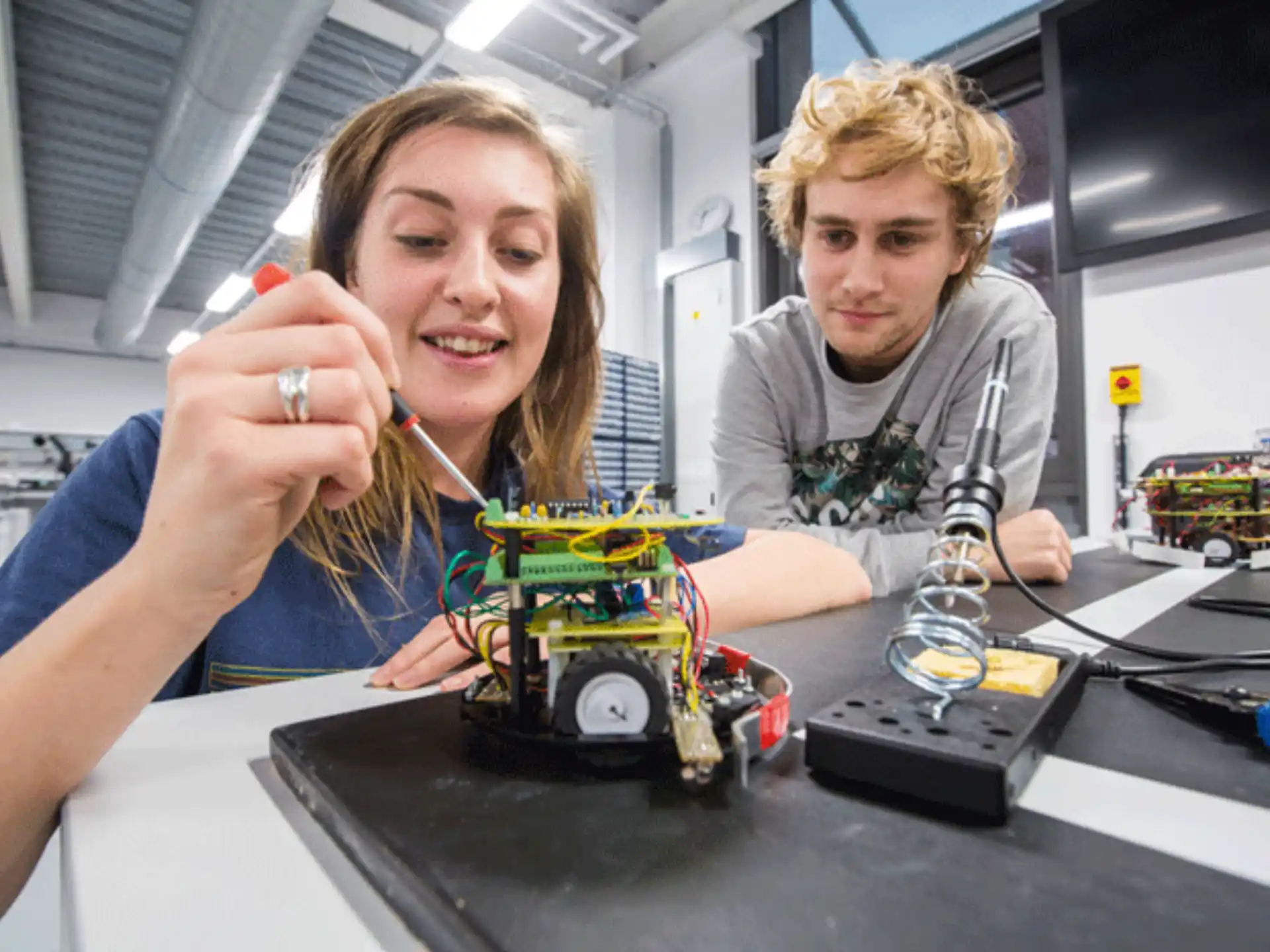 a woman and a man working on a toy car