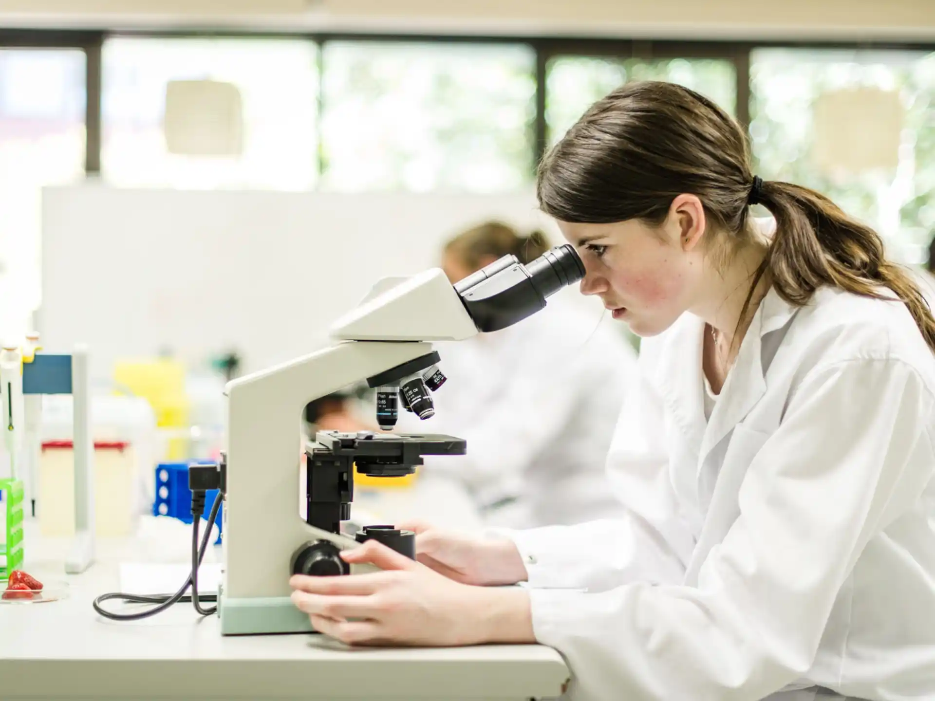 a woman looking through a microscope