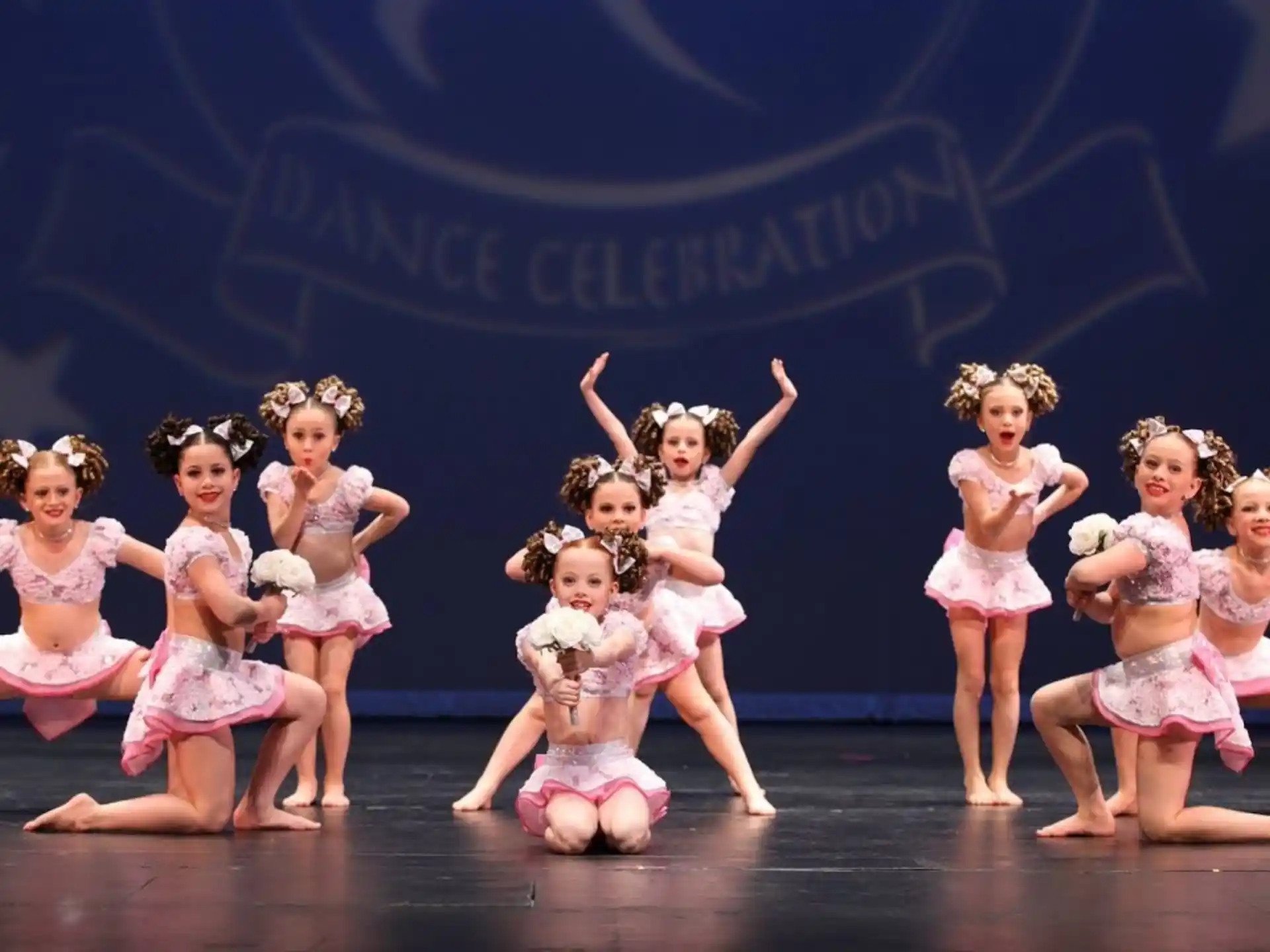 a group of girls in dresses dancing