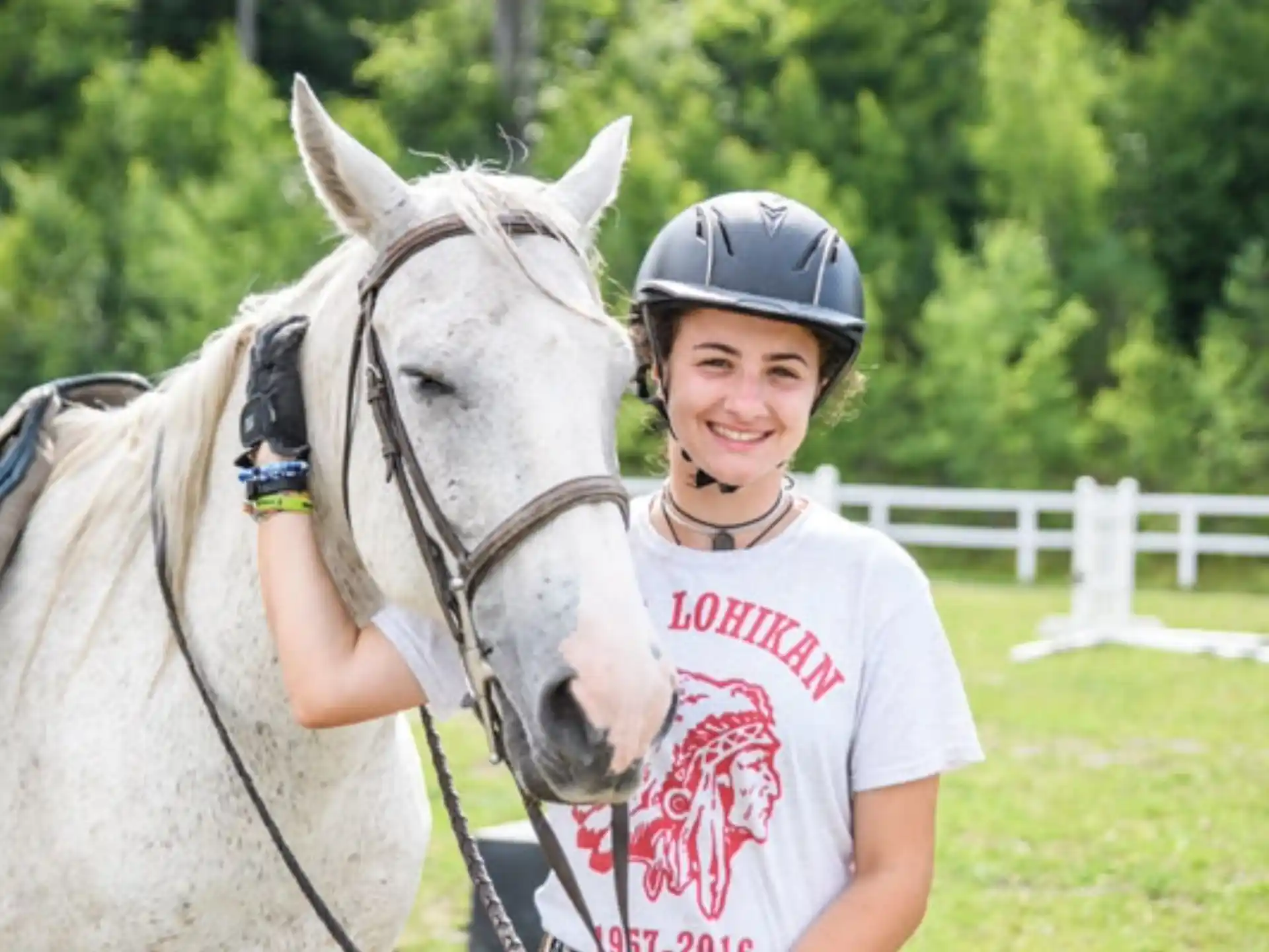 a girl with a helmet on a horse