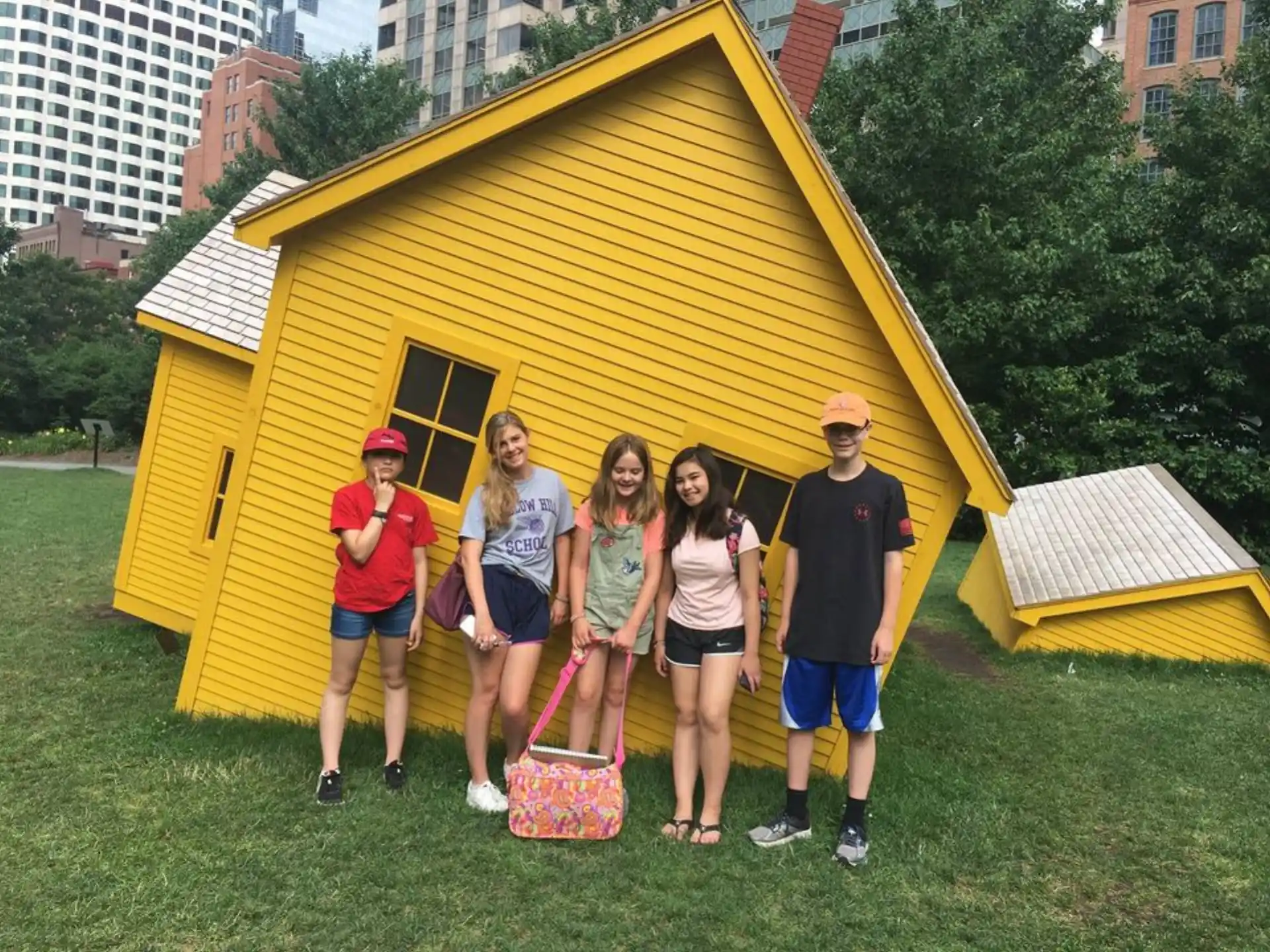 a group of people posing for a photo in front of a yellow house