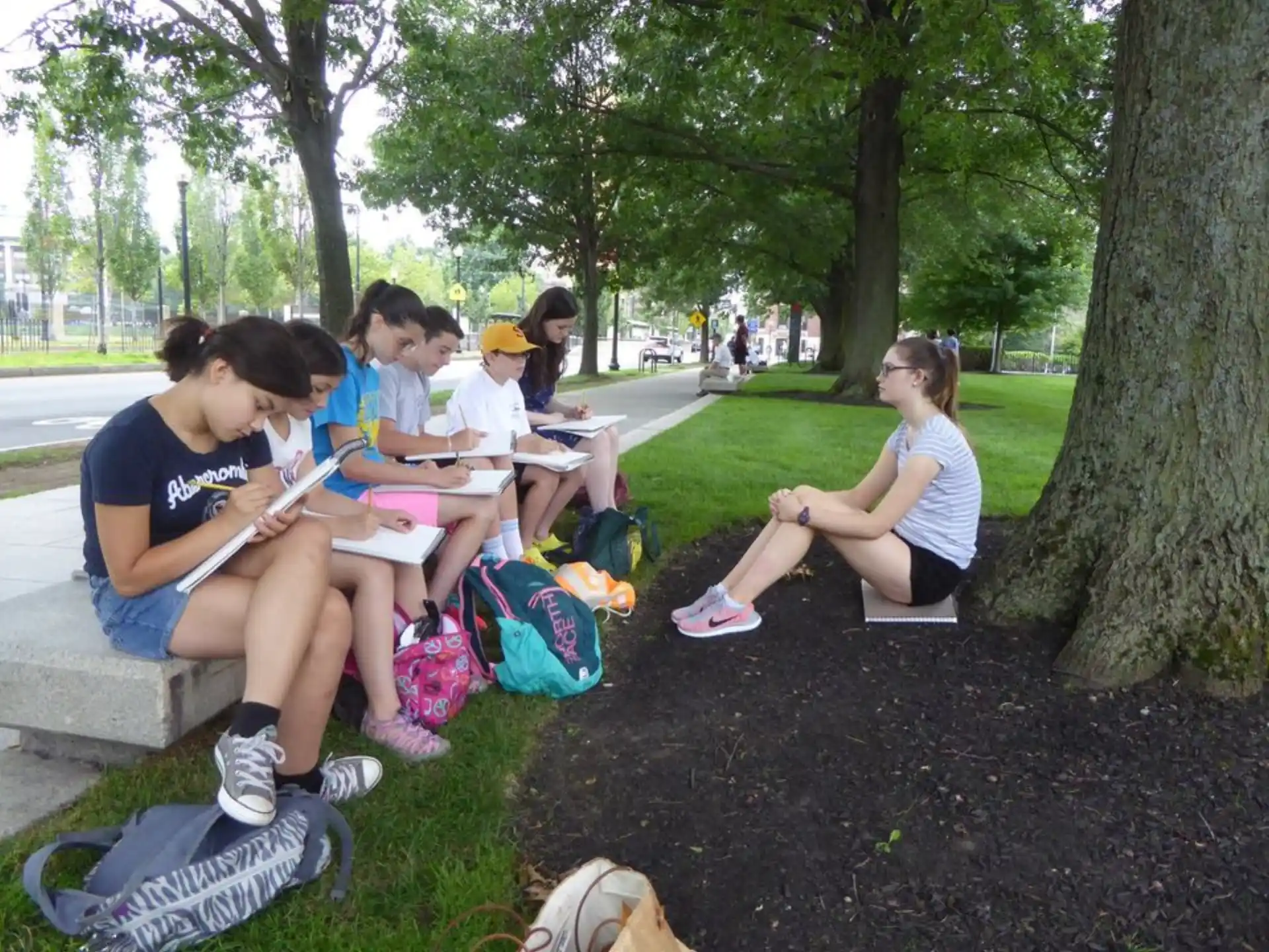 a group of people sitting on a bench in a park