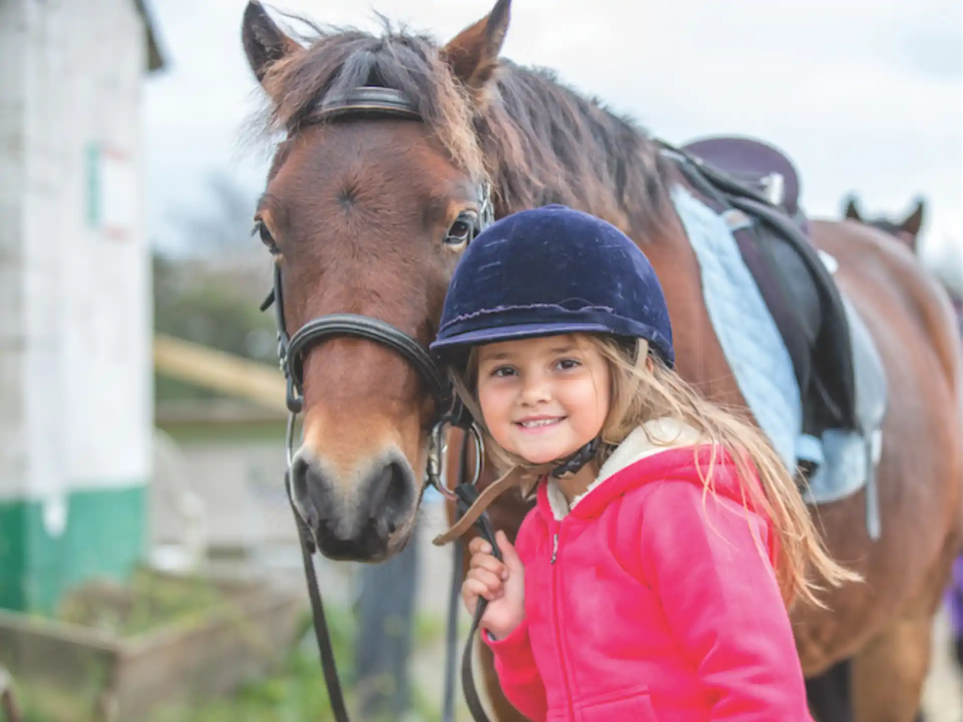 a girl standing next to a horse