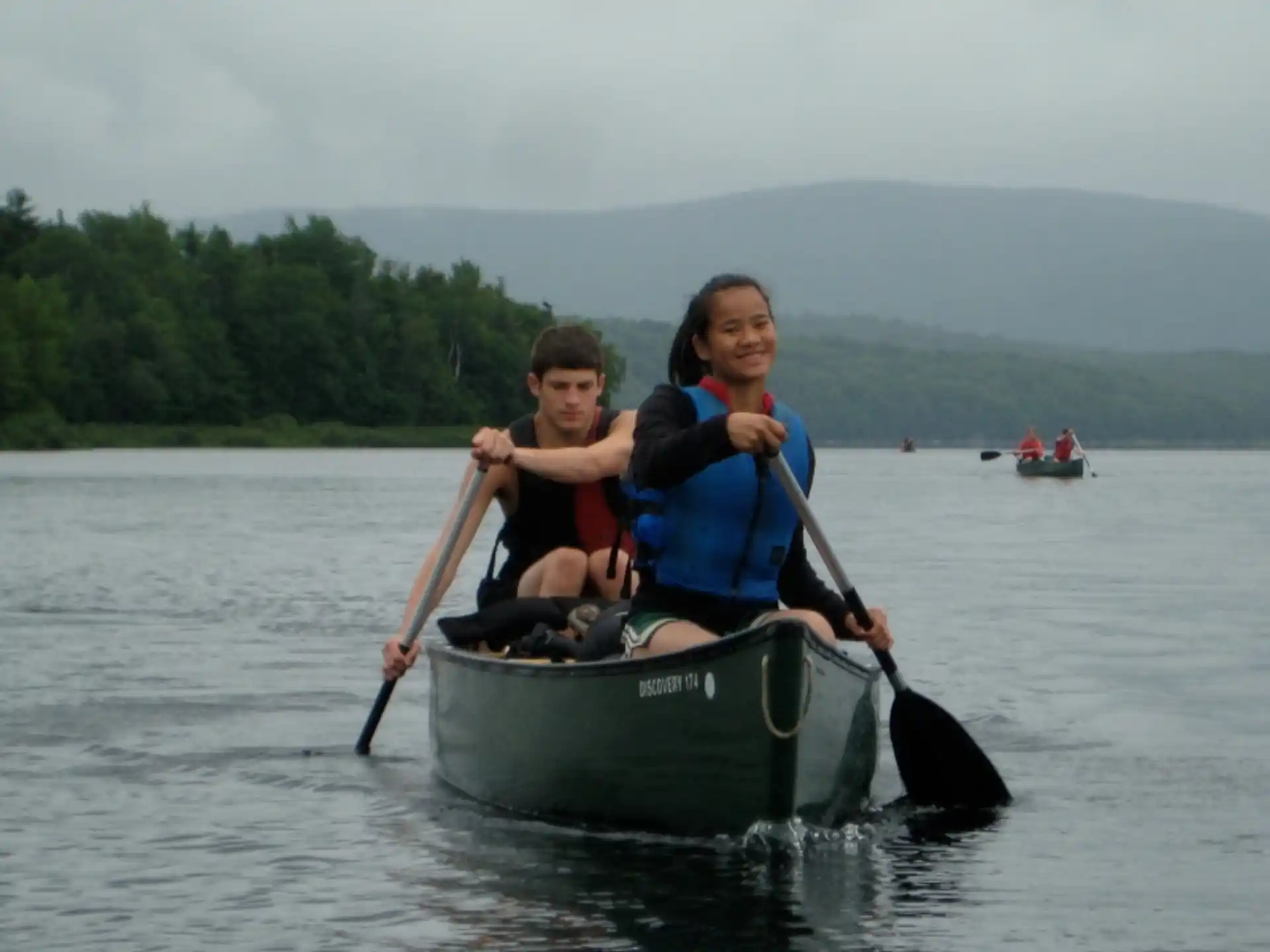 a couple of people in a canoe on a lake