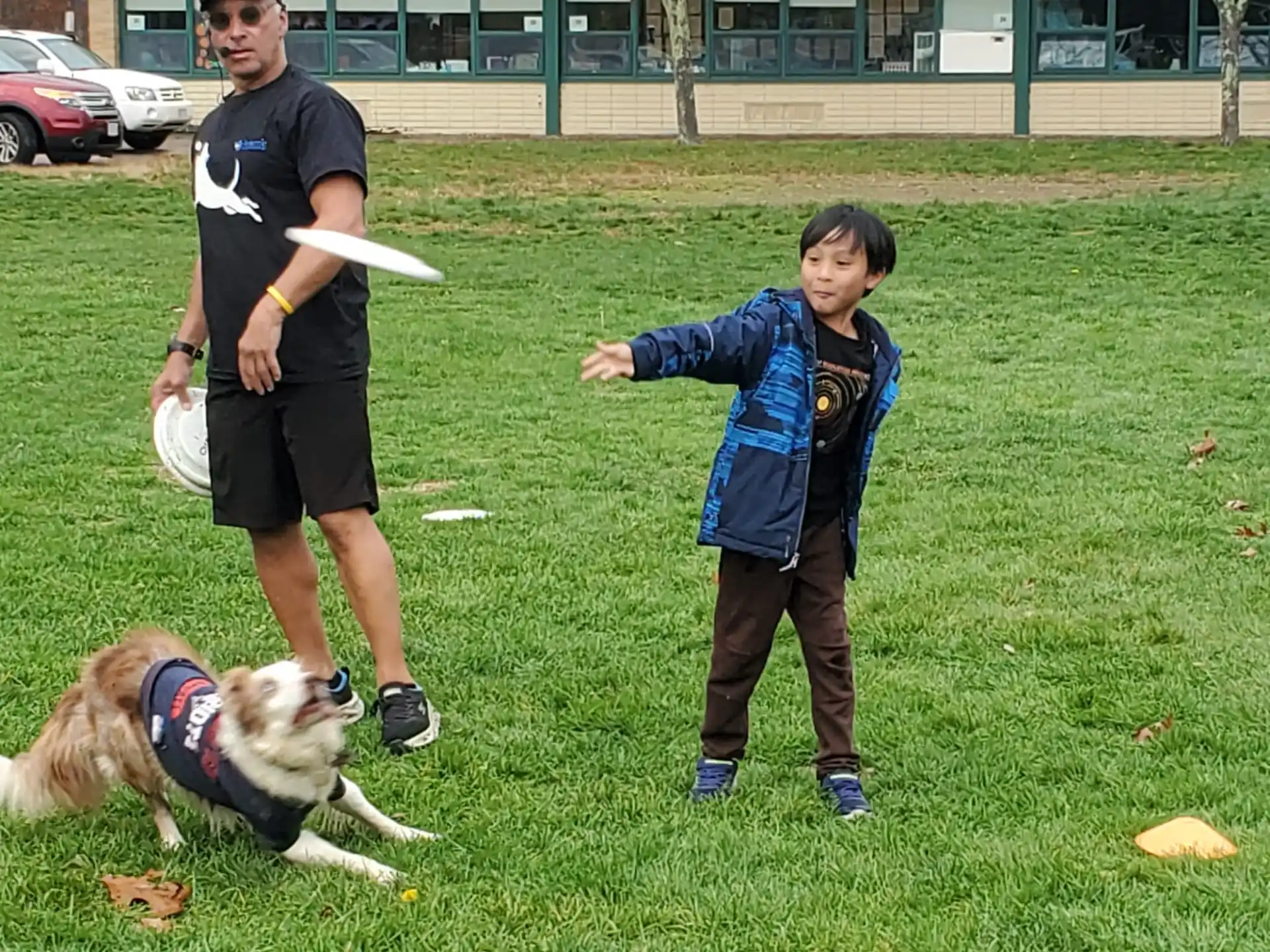 a person and a boy playing with a dog